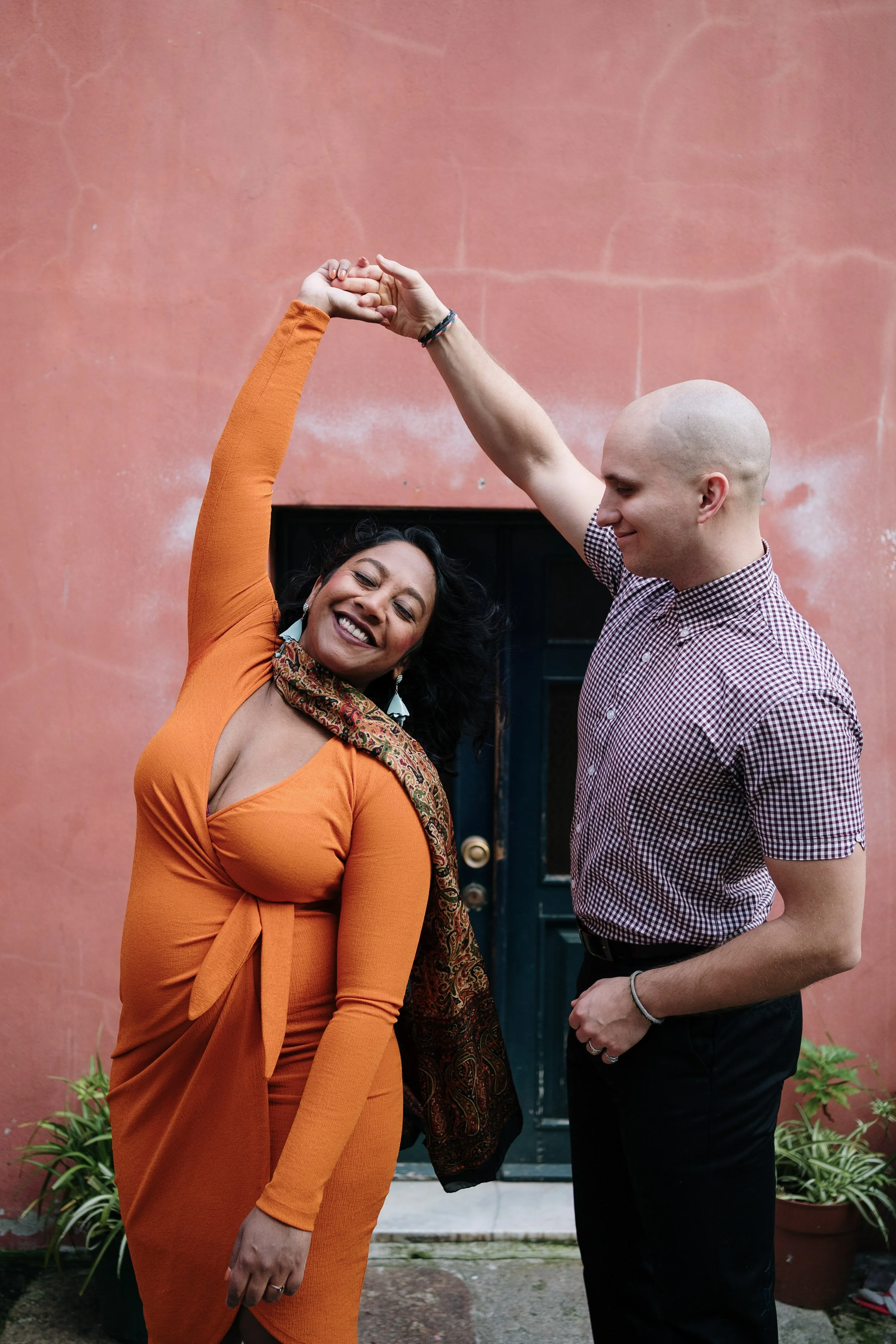 Candid engagement photography in Portugal, couple laughing and twirling during outdoor session.