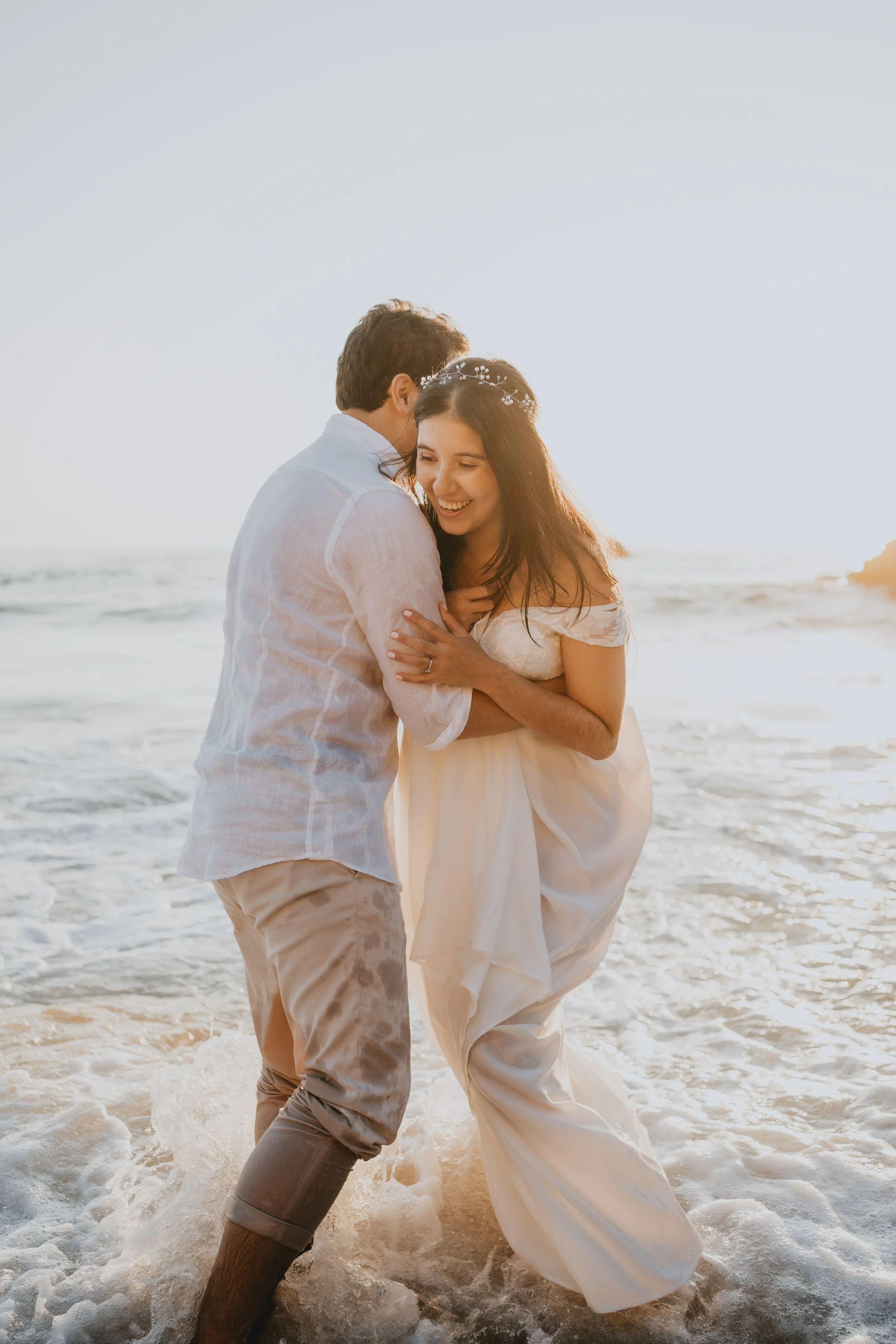 Romantic embrace during golden hour elopement at Adraga Beach Sintra Portugal