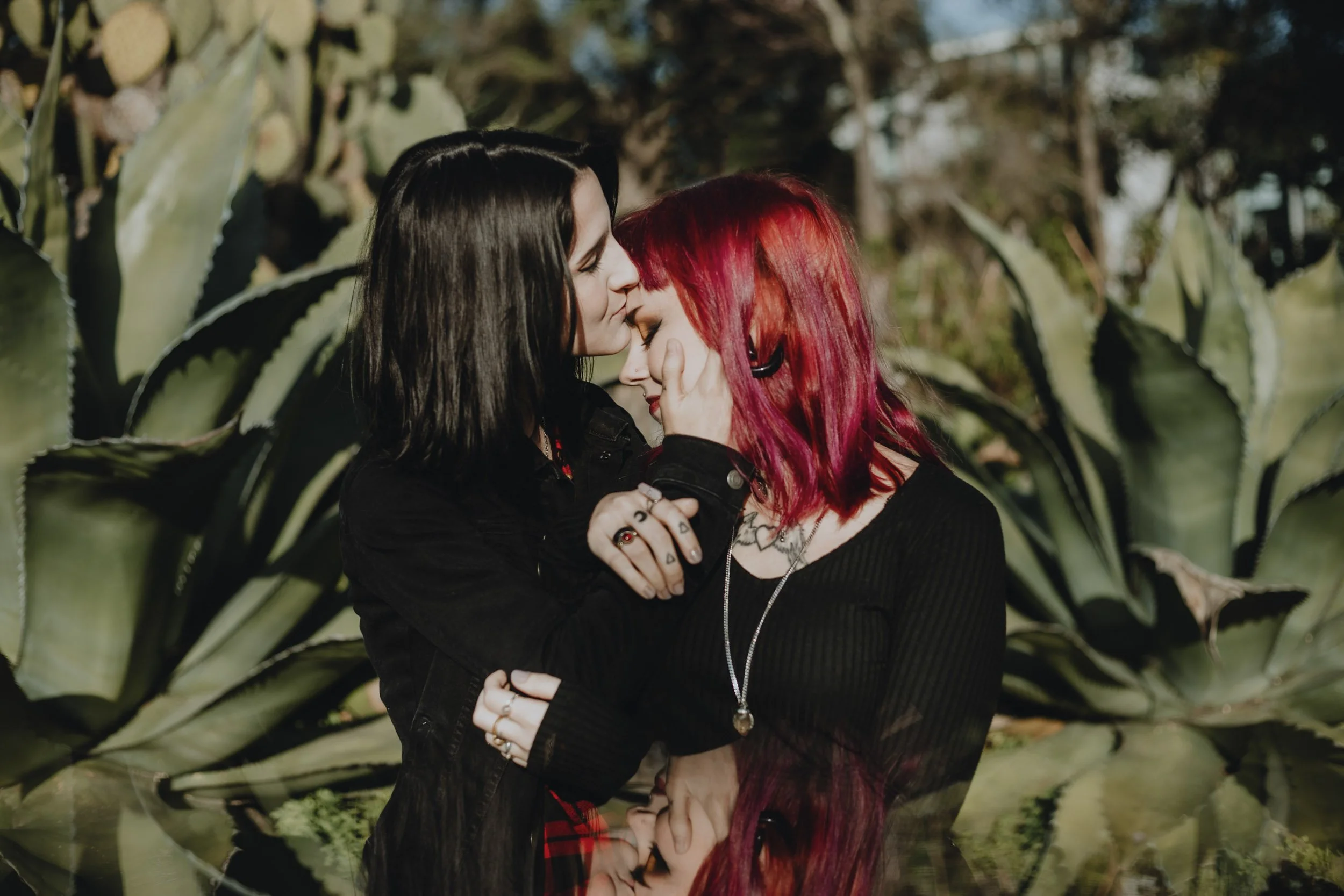 Alternative engagement photography in Portugal, couple embracing in lush natural setting.