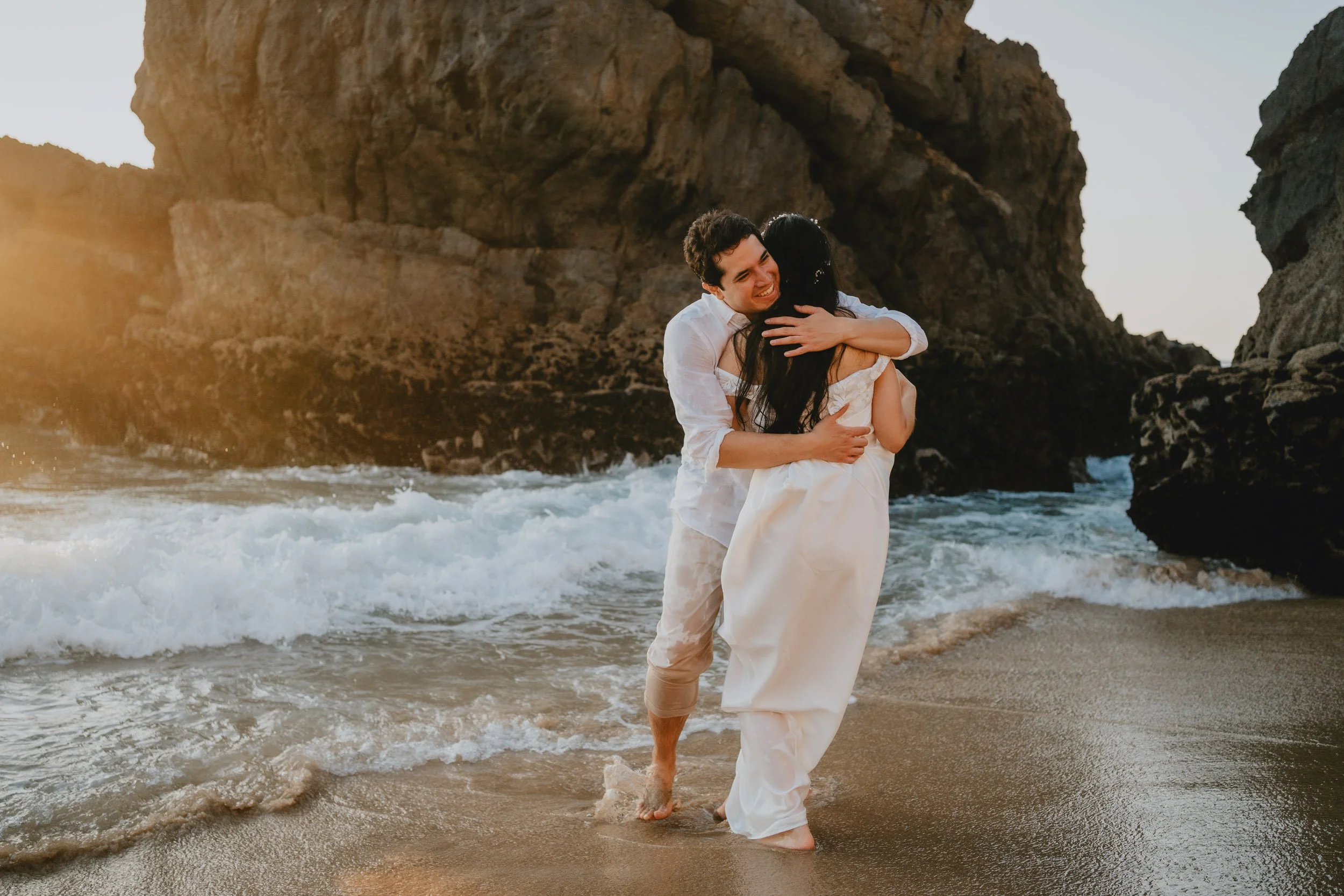 Newly married couple embracing by the sea during sunset elopement in Sintra Portugal