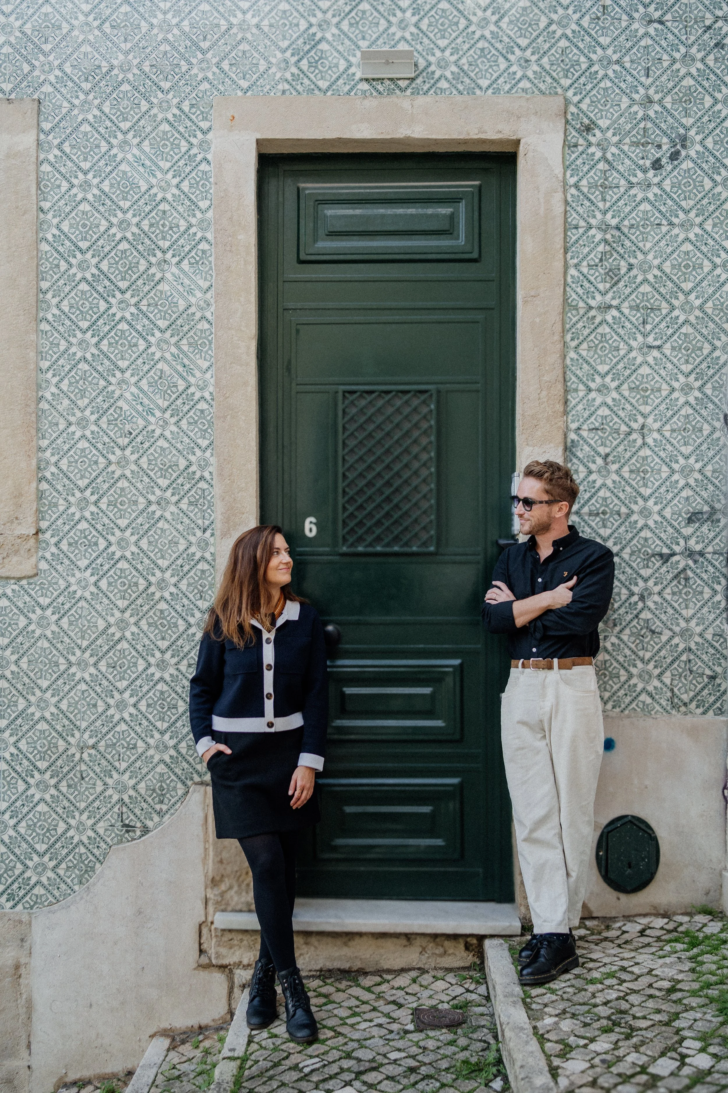 Engagement photography in Lisbon, couple standing together in front of traditional green door.