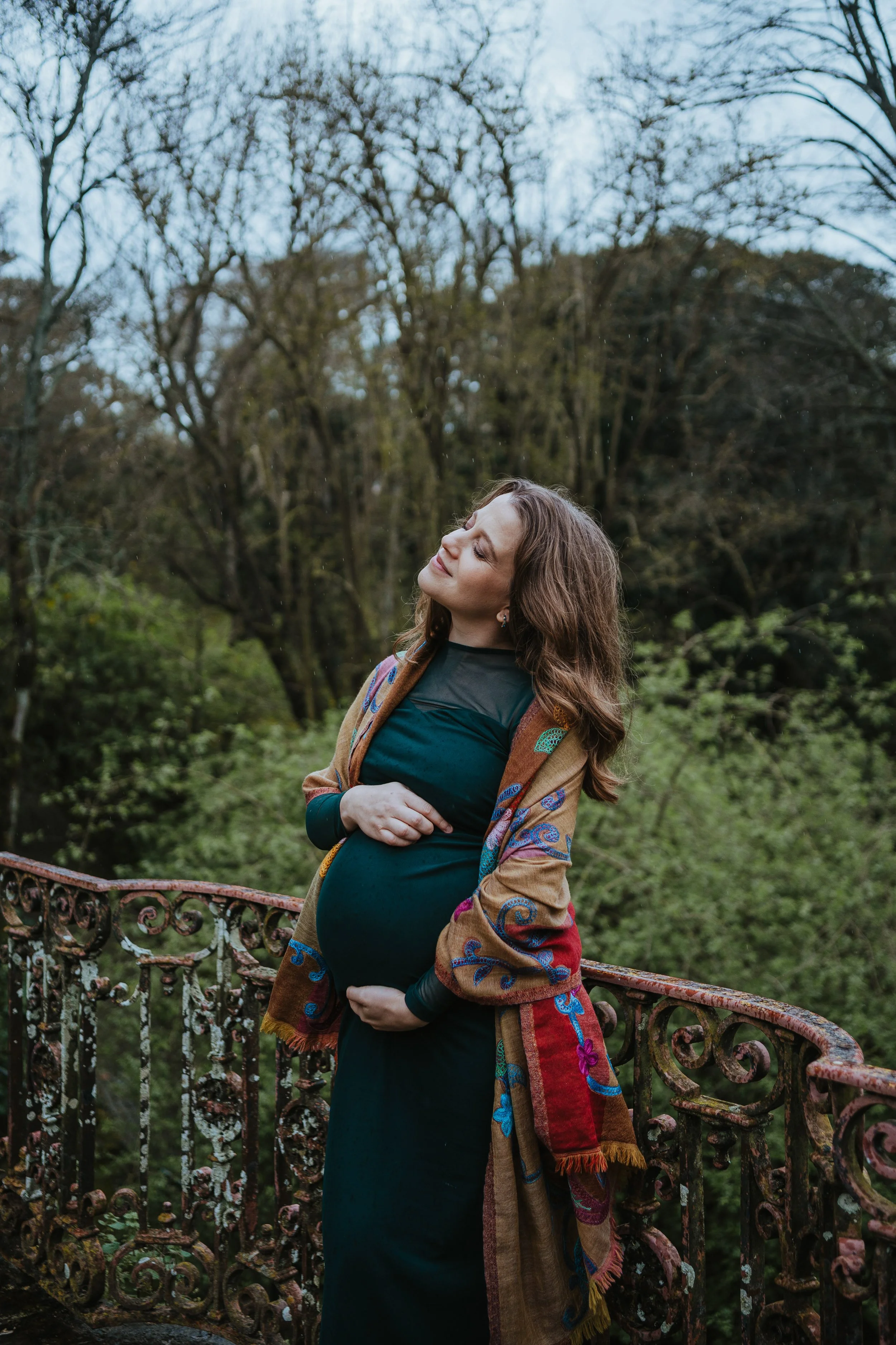 Outdoor maternity photoshoot in Portugal capturing couple embracing during pregnancy session in nature.
