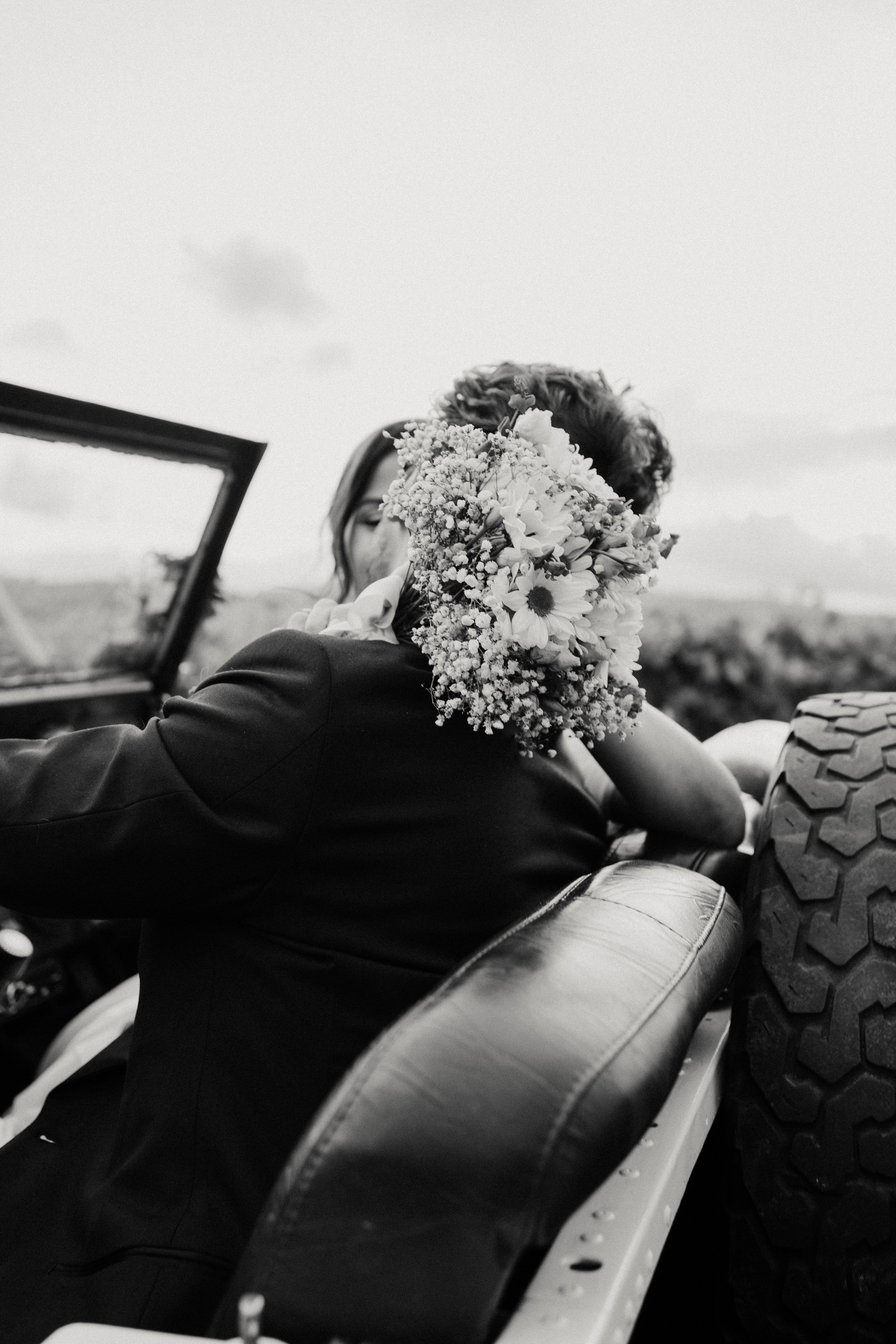 Documentary-style black and white wedding photography capturing emotional candid moment between bride and groom