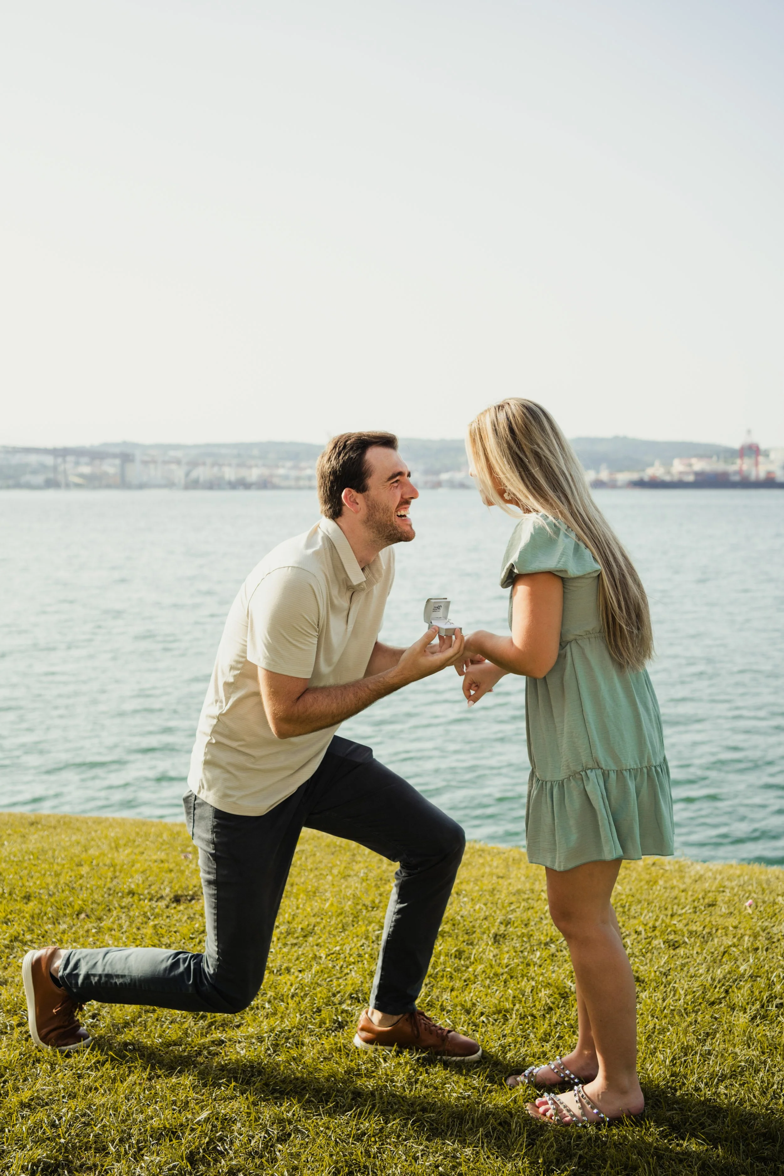 Engagement photography in Portugal, surprise proposal by the waterfront during golden hour.