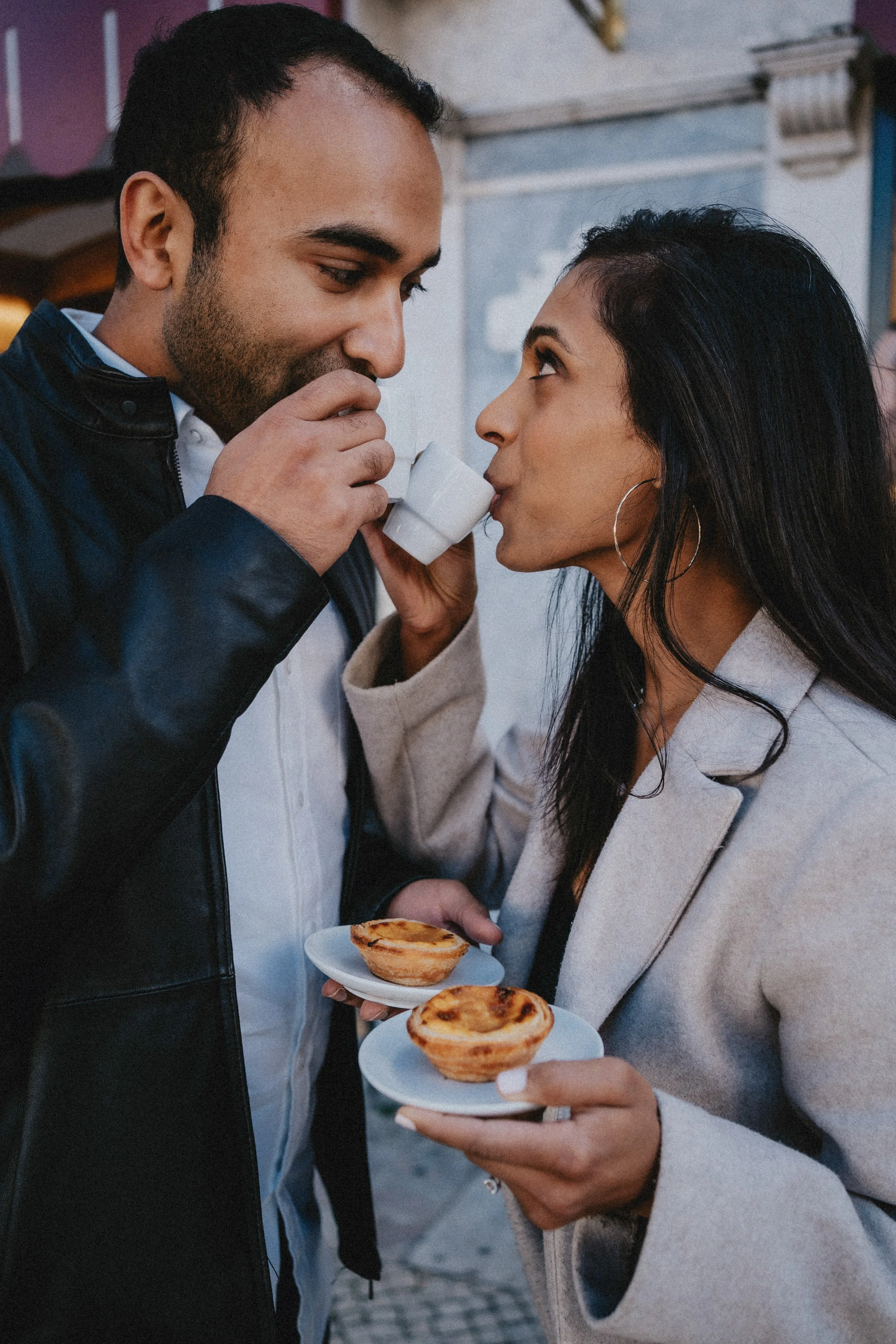 Romantic engagement photography in Lisbon, couple eating pastel de nata in downtown.