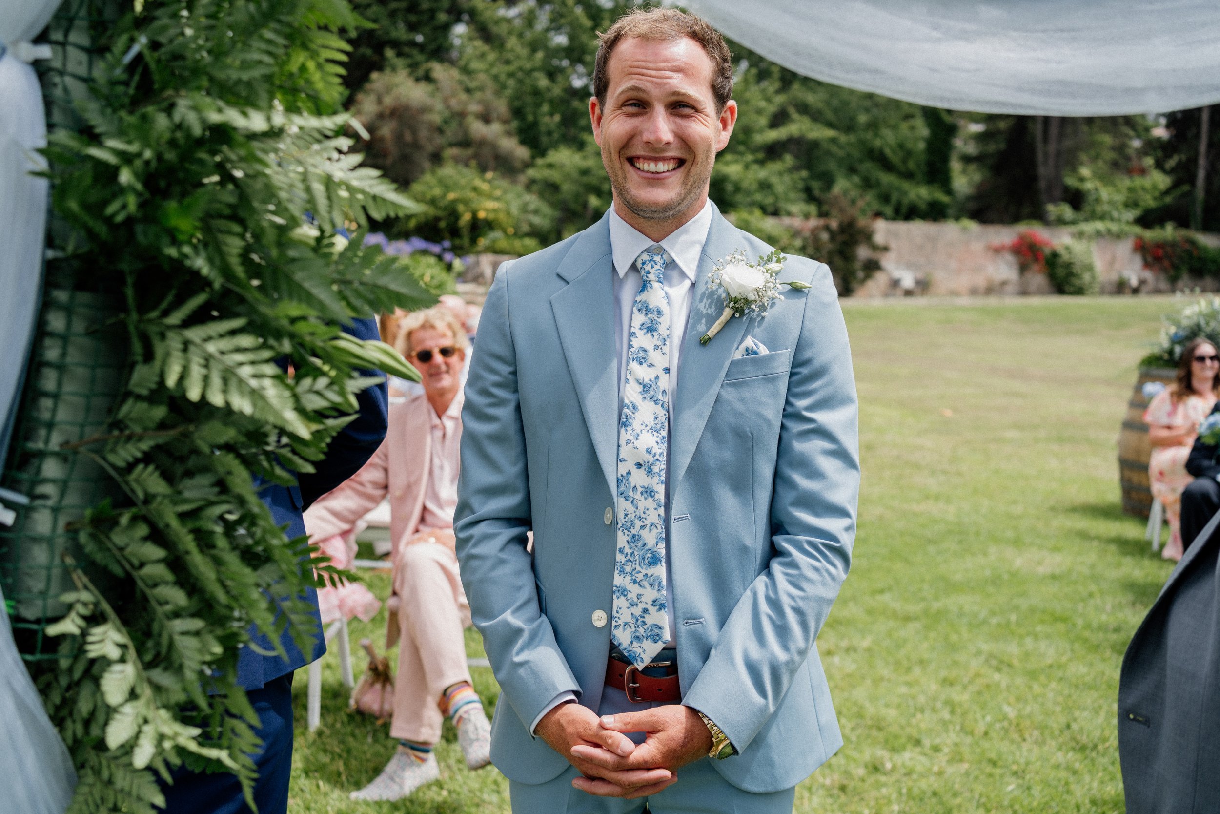 Editorial-style groom portrait in light blue suit during outdoor wedding in Portugal