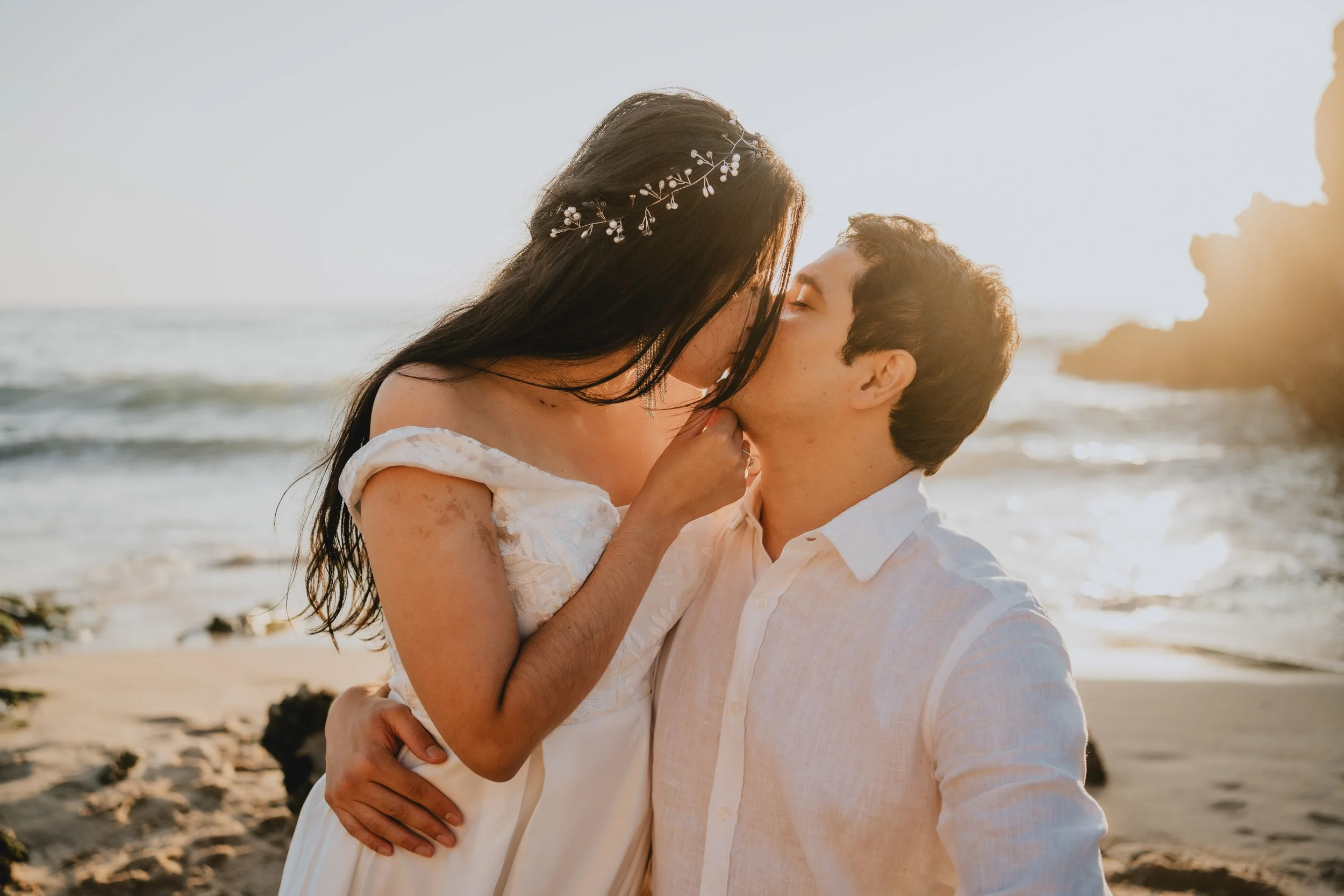 Intimate sunset kiss during beach elopement at Praia da Adraga in Sintra Portugal