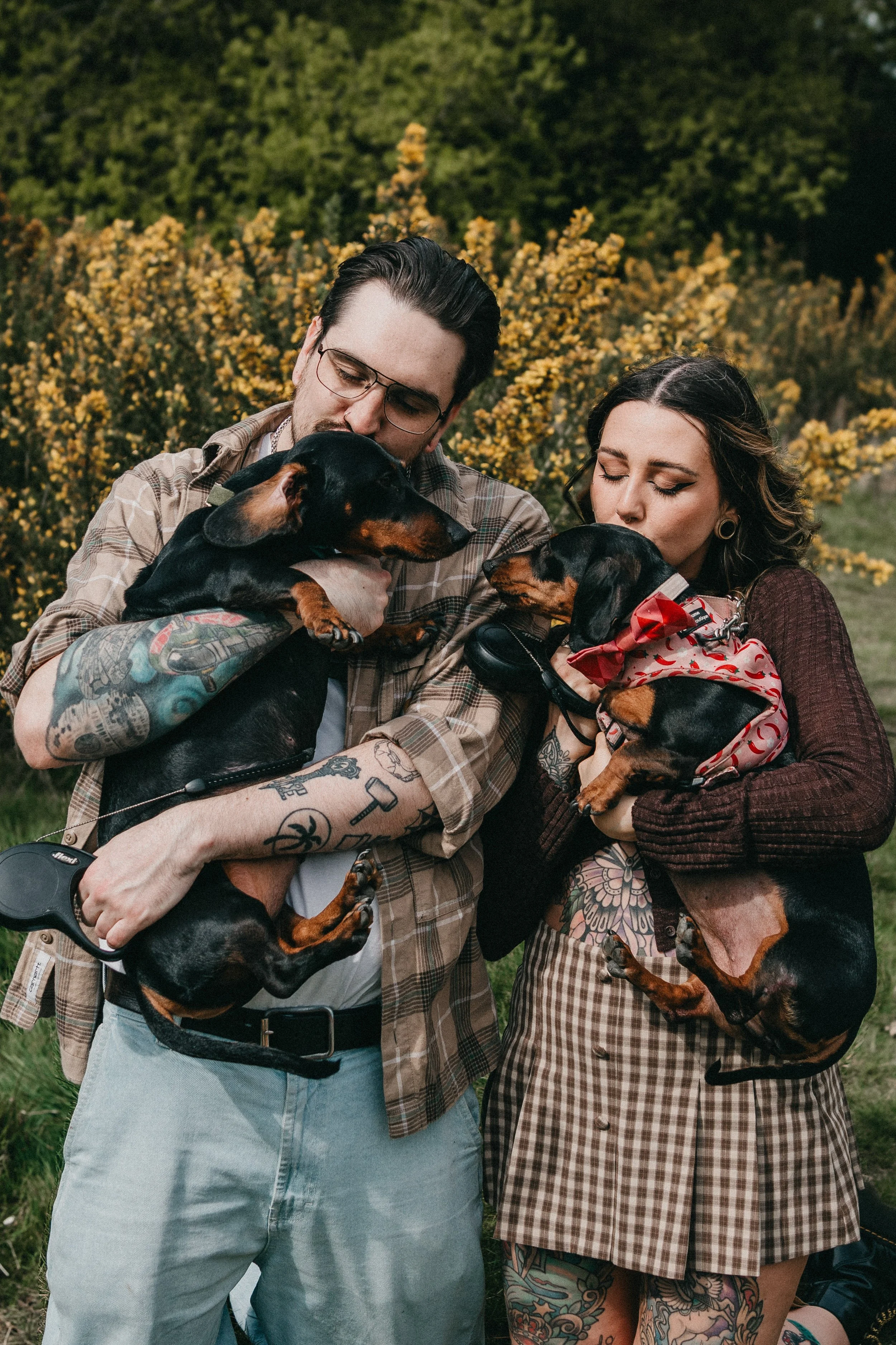 Engagement photography in London, couple posing outdoors with their dogs during natural countryside session.
