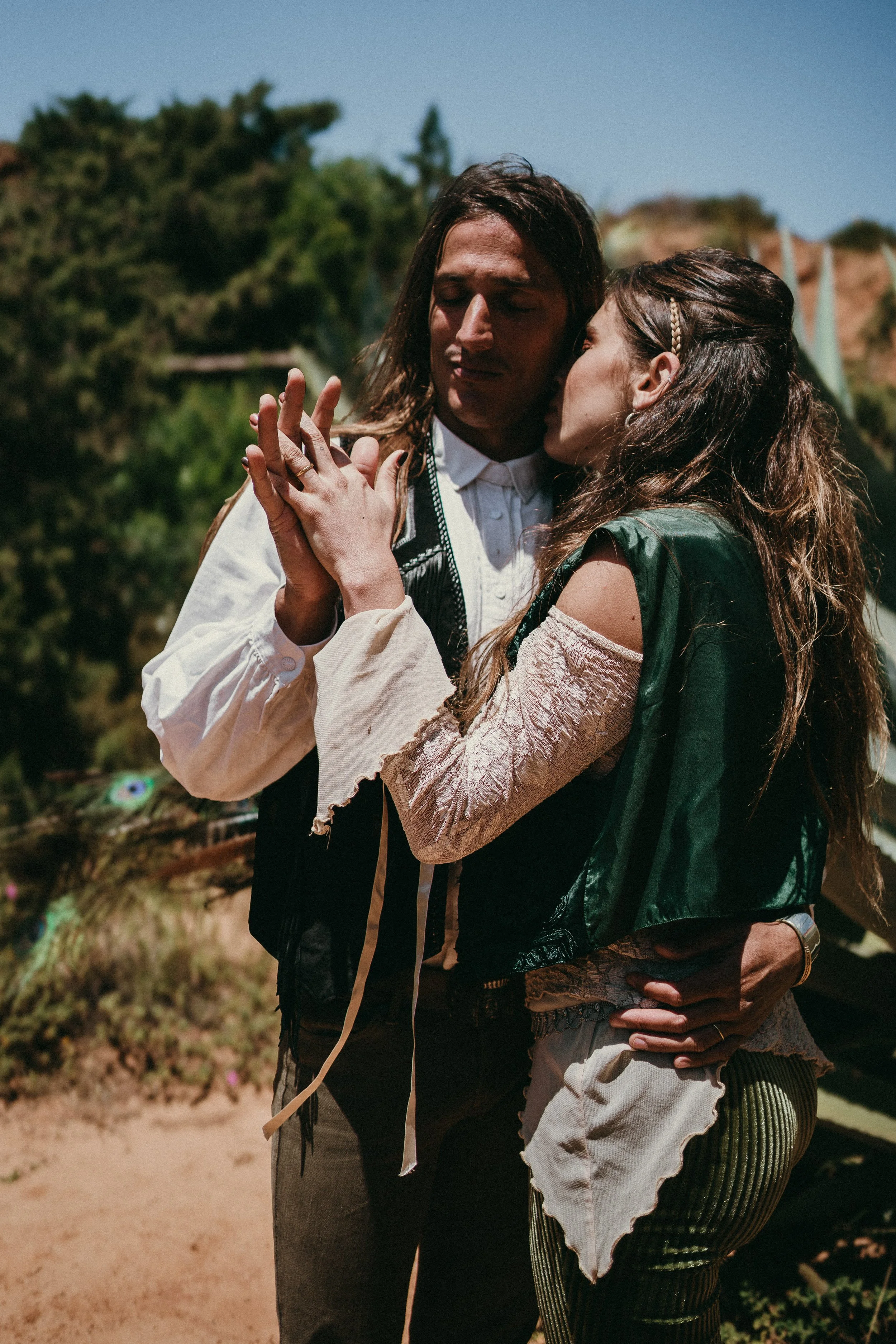 Bohemian couple embracing during adventure elopement on coastal cliffs in Portugal