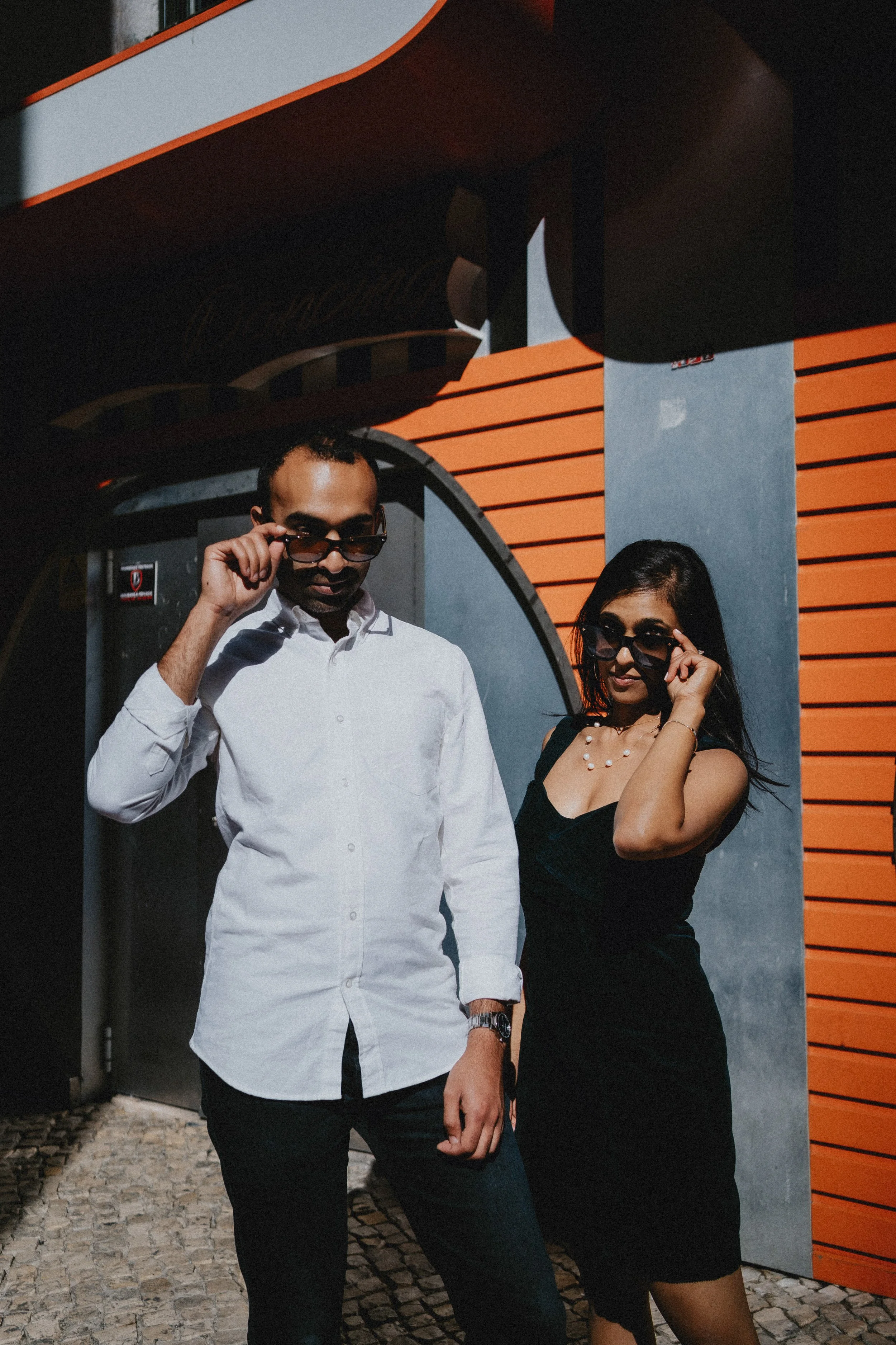 Candid engagement photography in Lisbon, couple walking together through colorful city street.