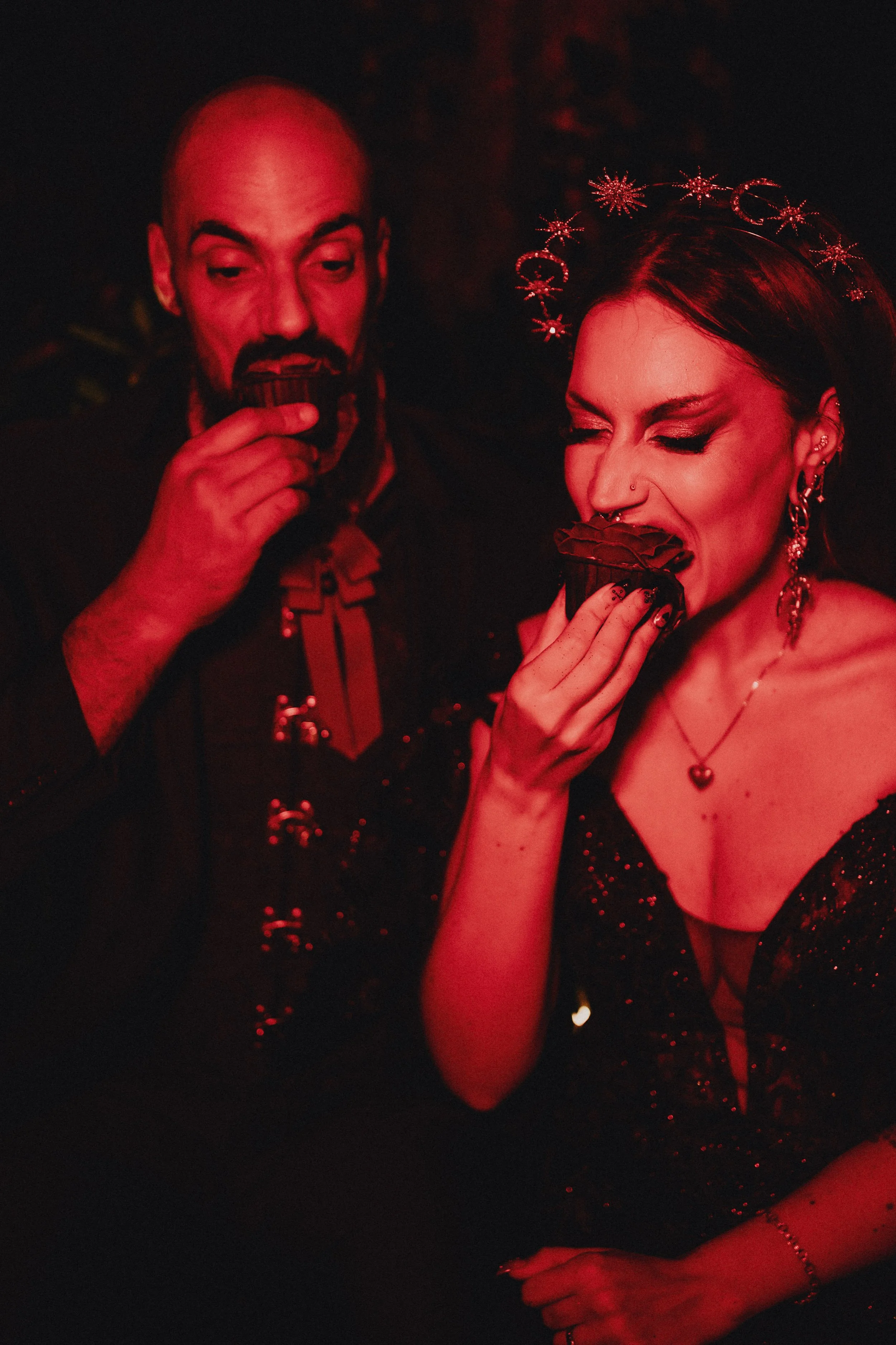 Cinematic red light portrait during alternative elopement in Portugal, couple eating cake