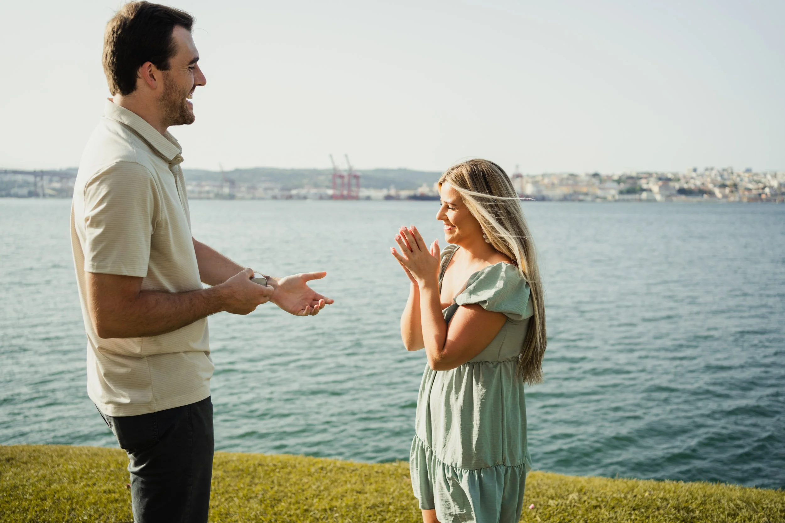 Engagement photography in Portugal, couple celebrating proposal near waterfront during outdoor session.