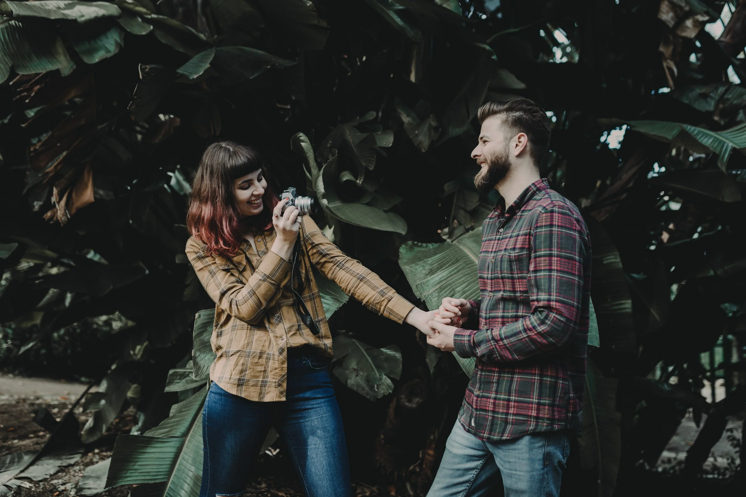 Moody engagement photography portrait of couple in creative low-light setting.