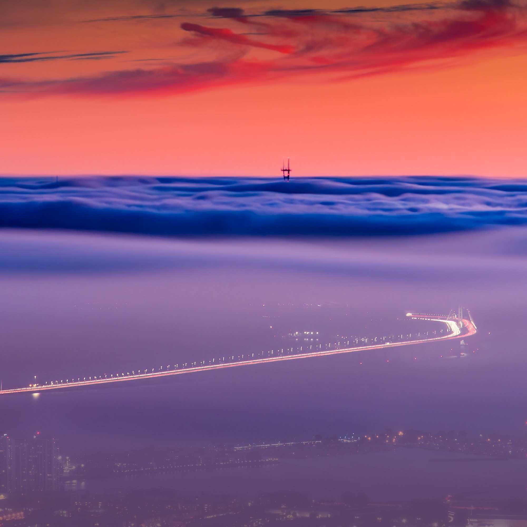 Long exposure of San Francisco fog at sunset from Berkeley Hills with Bay Bridge towers