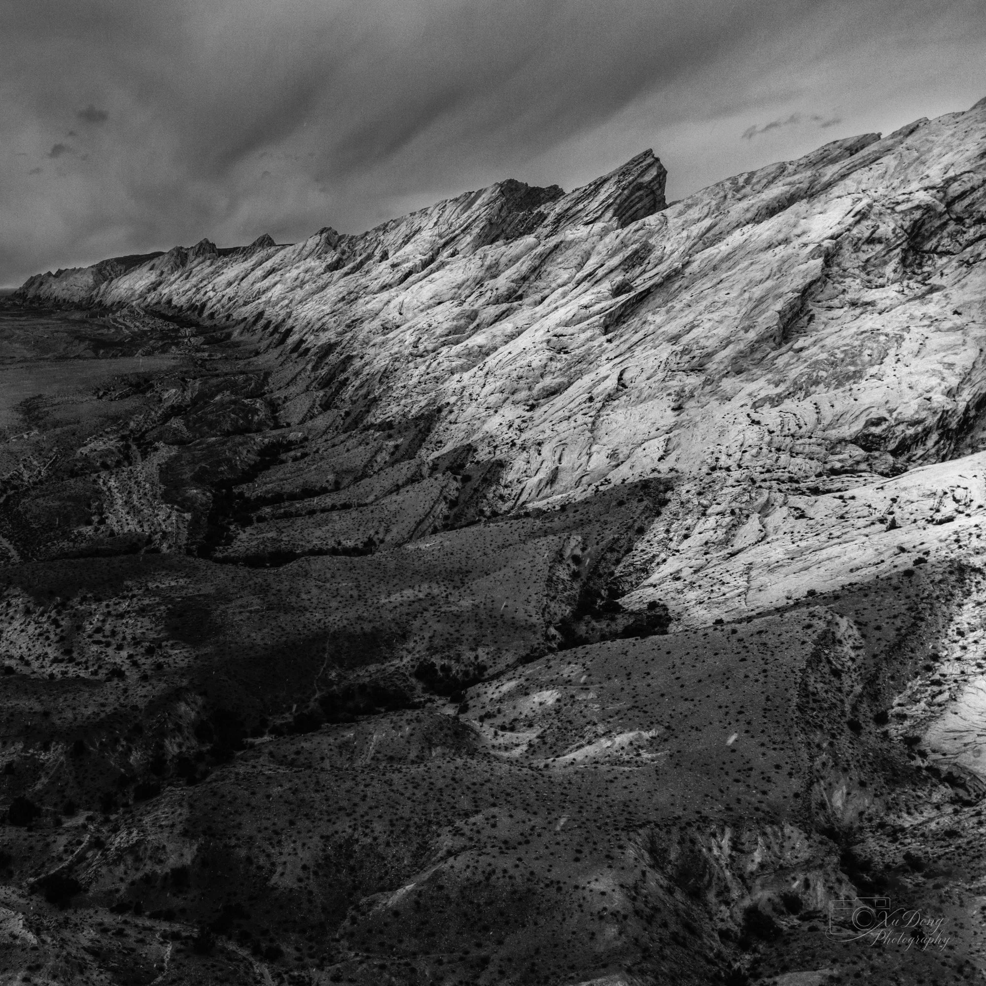 Minimalist black and white mountain ridge photography highlighting geological texture and lines