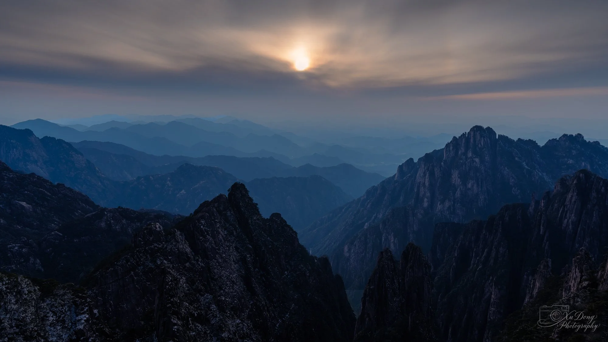 Warm, golden light illuminating the granite textures of Yellow Mountain at sunset, emphasizing the mountain's rugged beauty