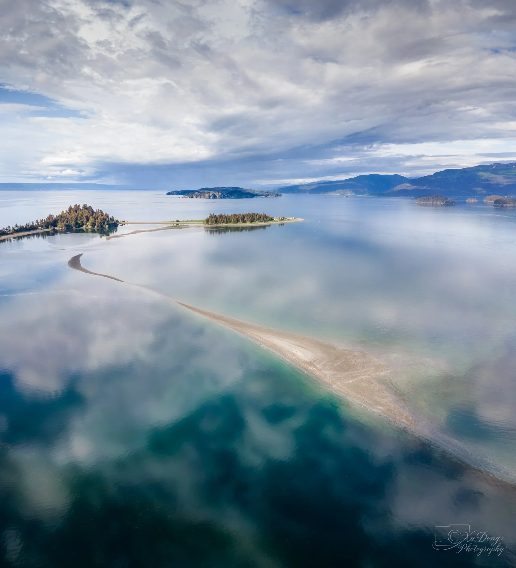 Aerial fine art photography of an island archipelago and sandbar in calm, crystalline turquoise waters, Alaska