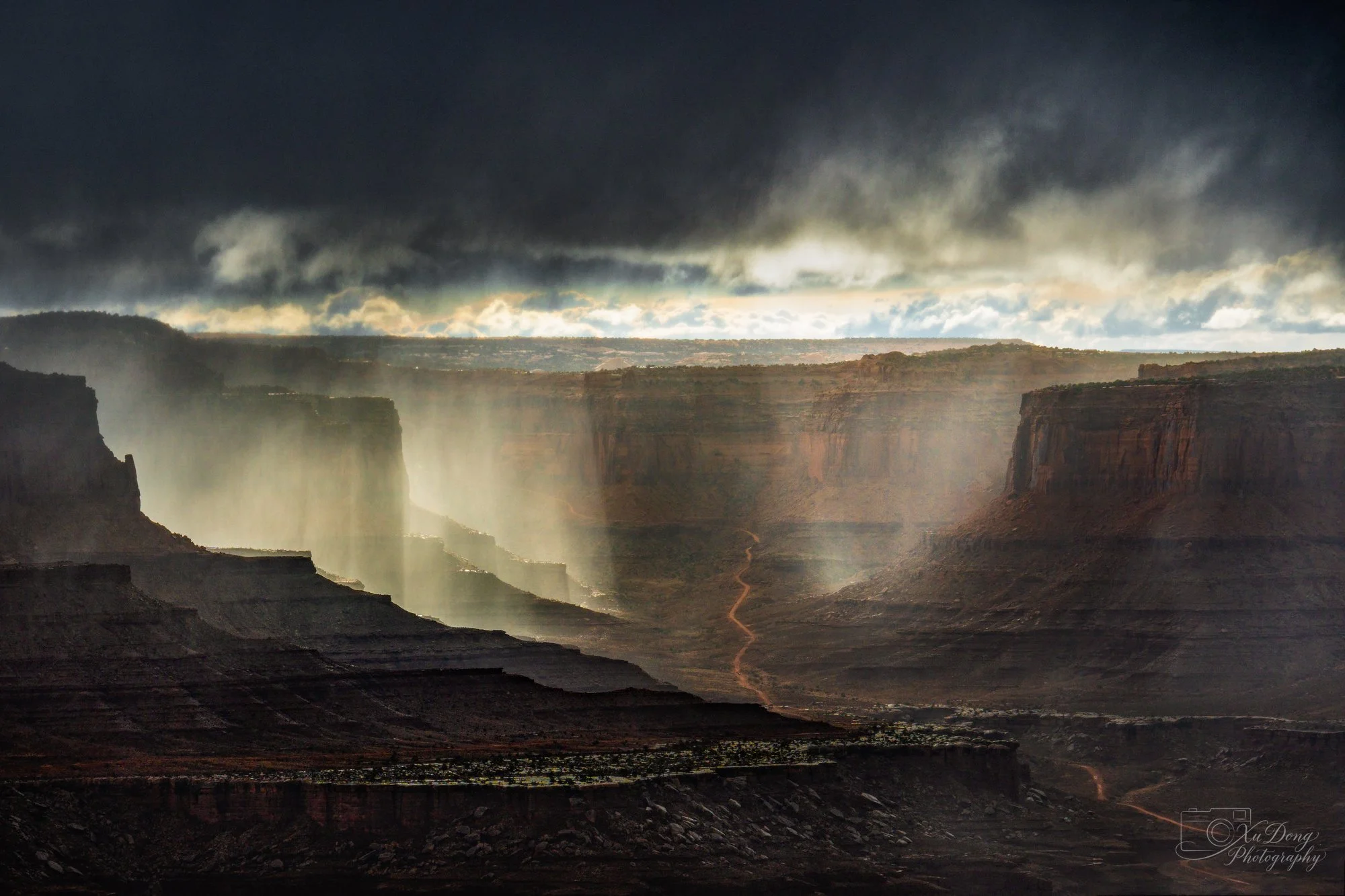 Dramatic storm clouds and sunbeams breaking over the mesas of Canyonlands National Park