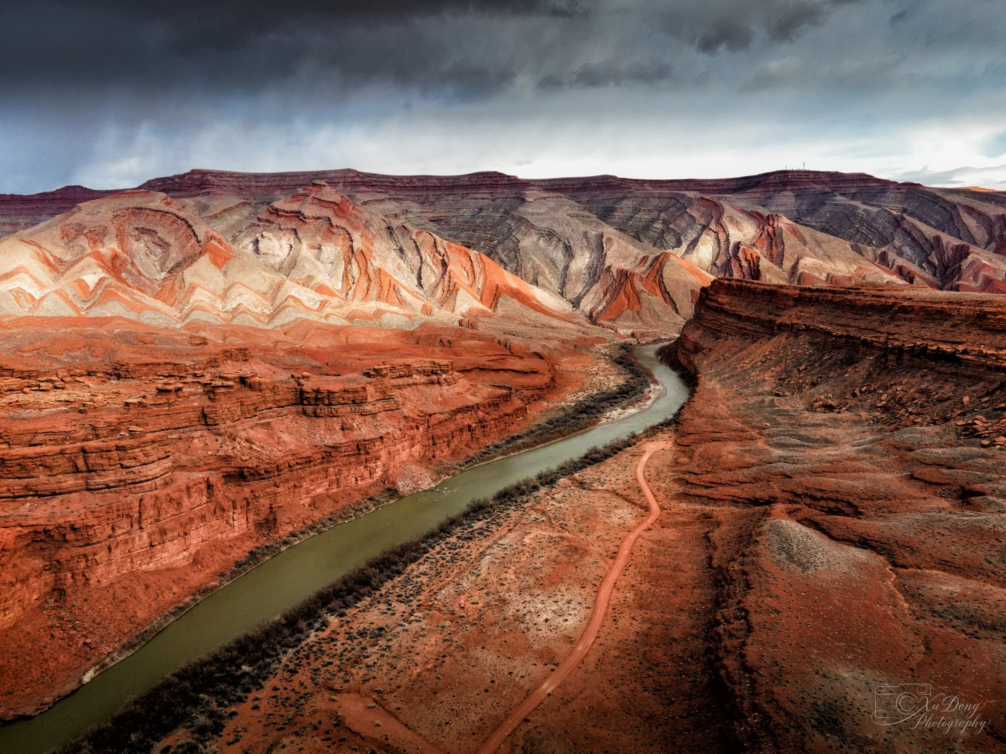 Aerial perspective of a winding river through a deep red rock canyon in the American Southwest