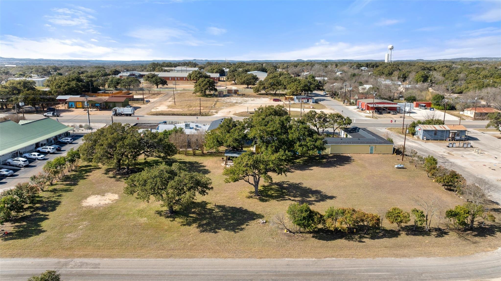 An aerial shot of the Swiss Lodge Motel in Blanco, Texas, showing it's large outdoor area speckled with live oak trees.
