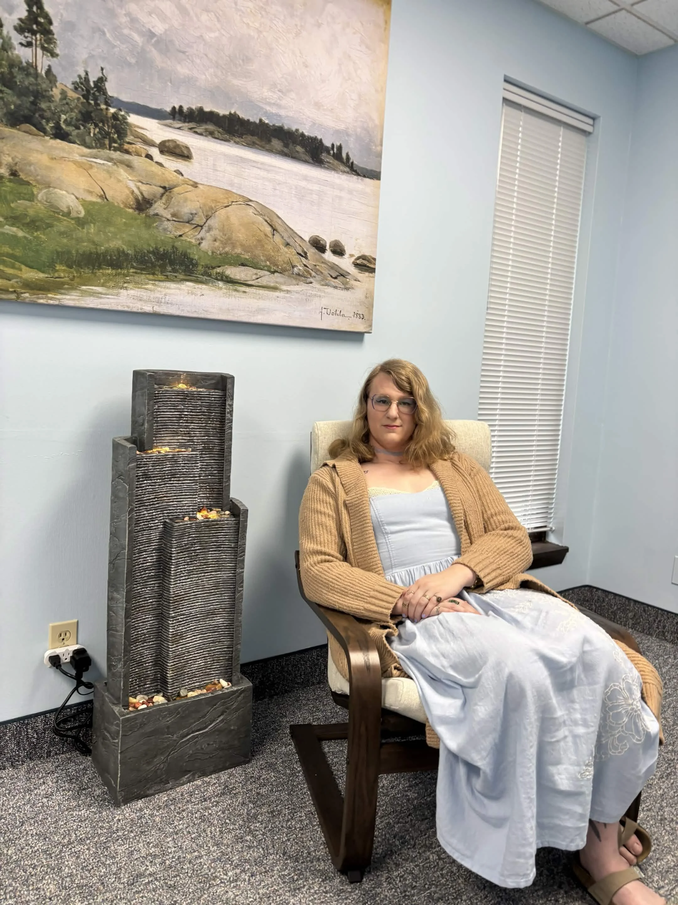 Nigel Turk, a counselor, sitting by a fountain and artwork of nature