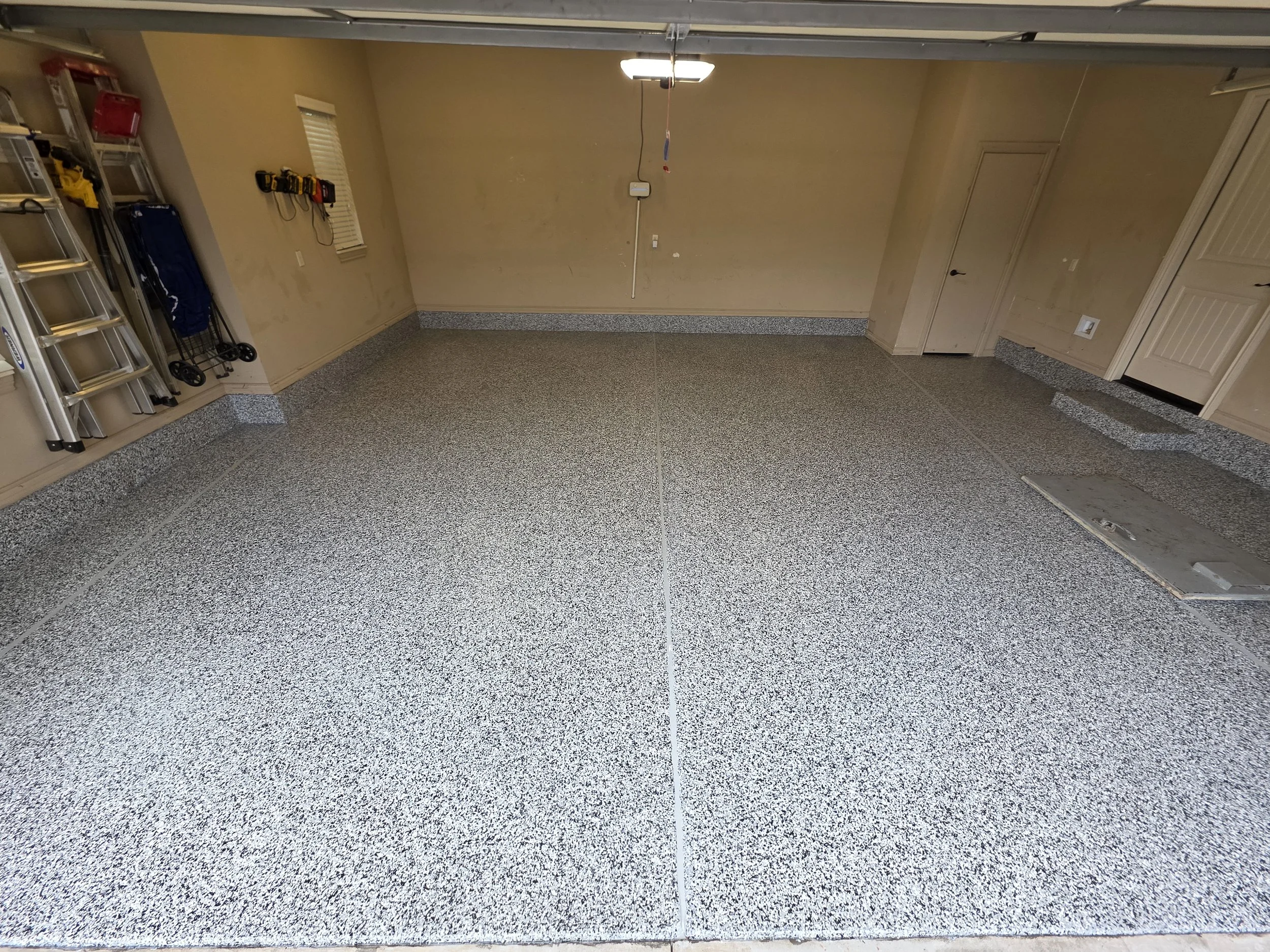 Phase 4 (Finished) - Polyaspartic topcoat applied over flakes. Expansion joints filled with gray caulking to imitate seamless floor.