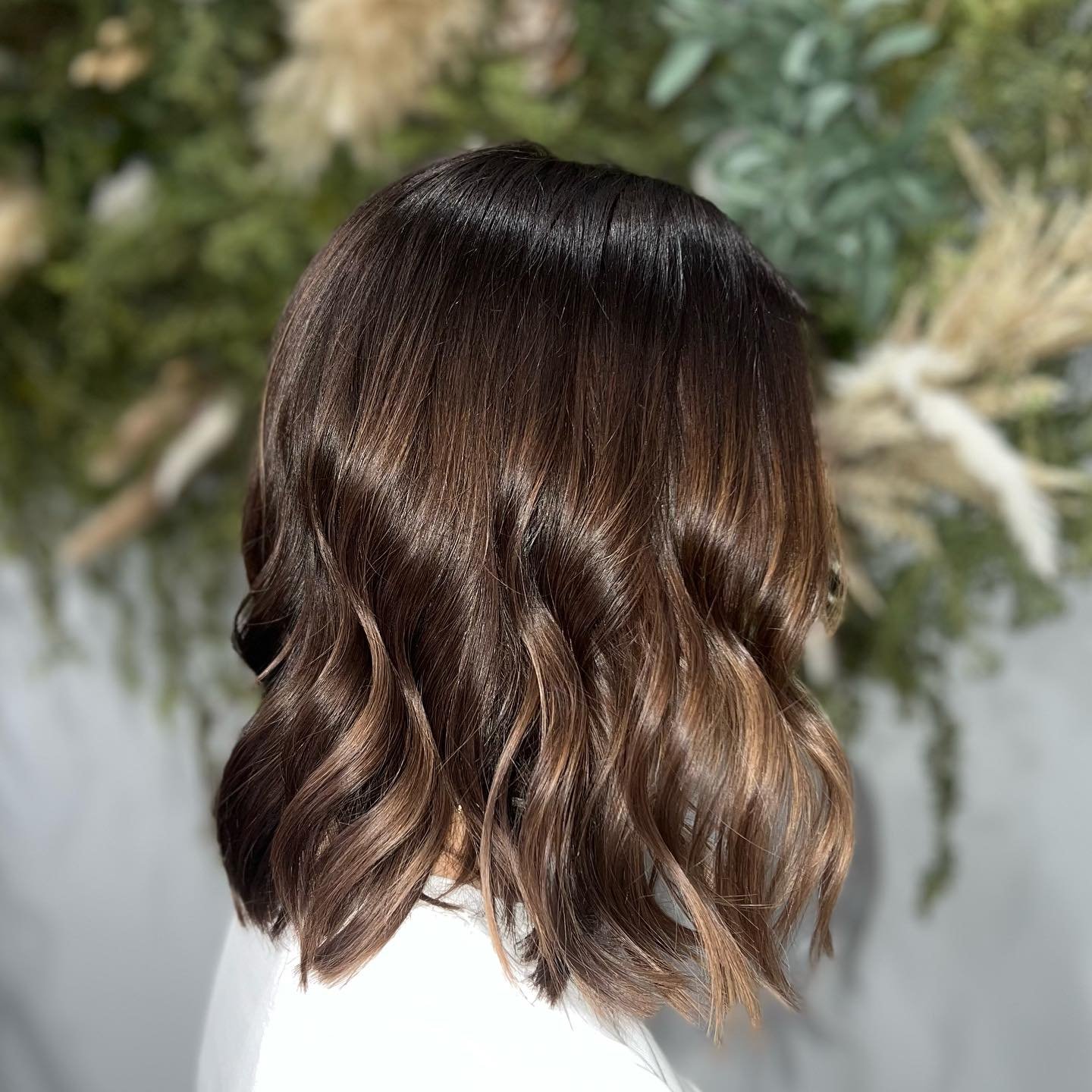 A woman with shoulder-length, wavy brown hair with highlights.