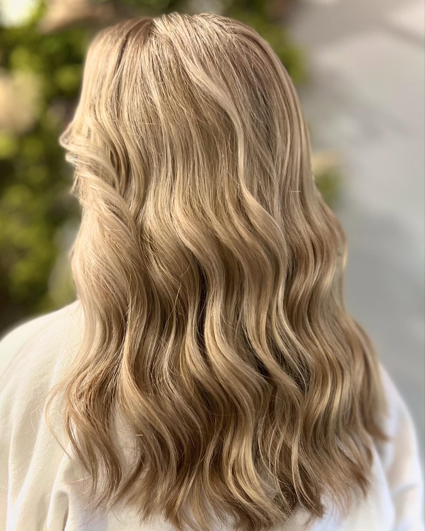Back view of a woman with long, wavy blonde hair