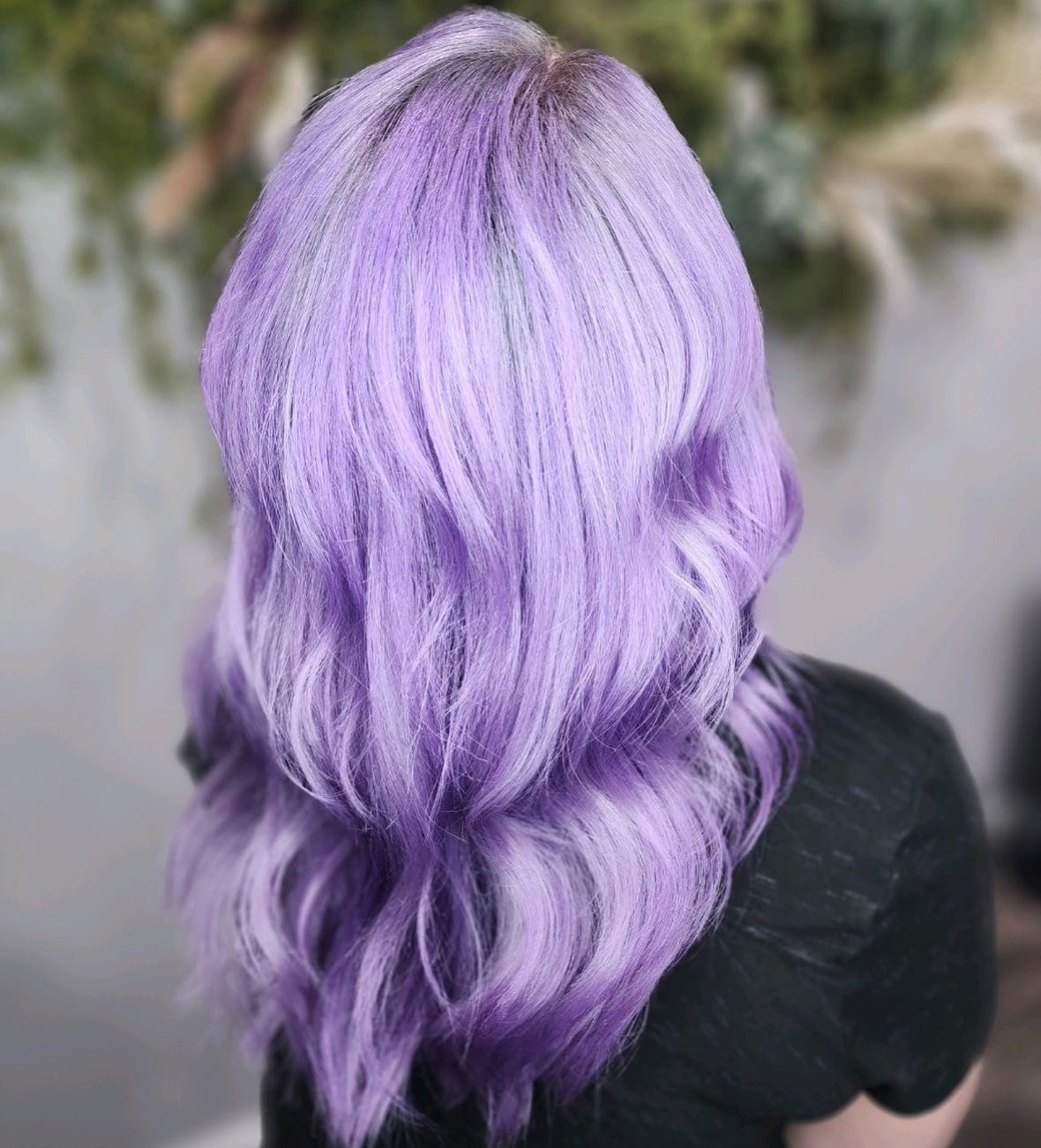 Back of a person's head with long, wavy, lavender-colored hair