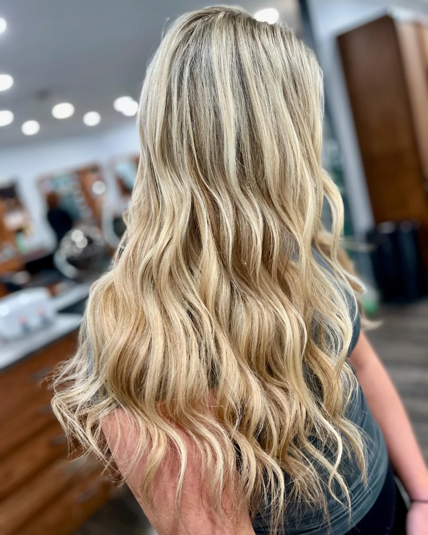 Blonde woman with wavy hair in a salon.
