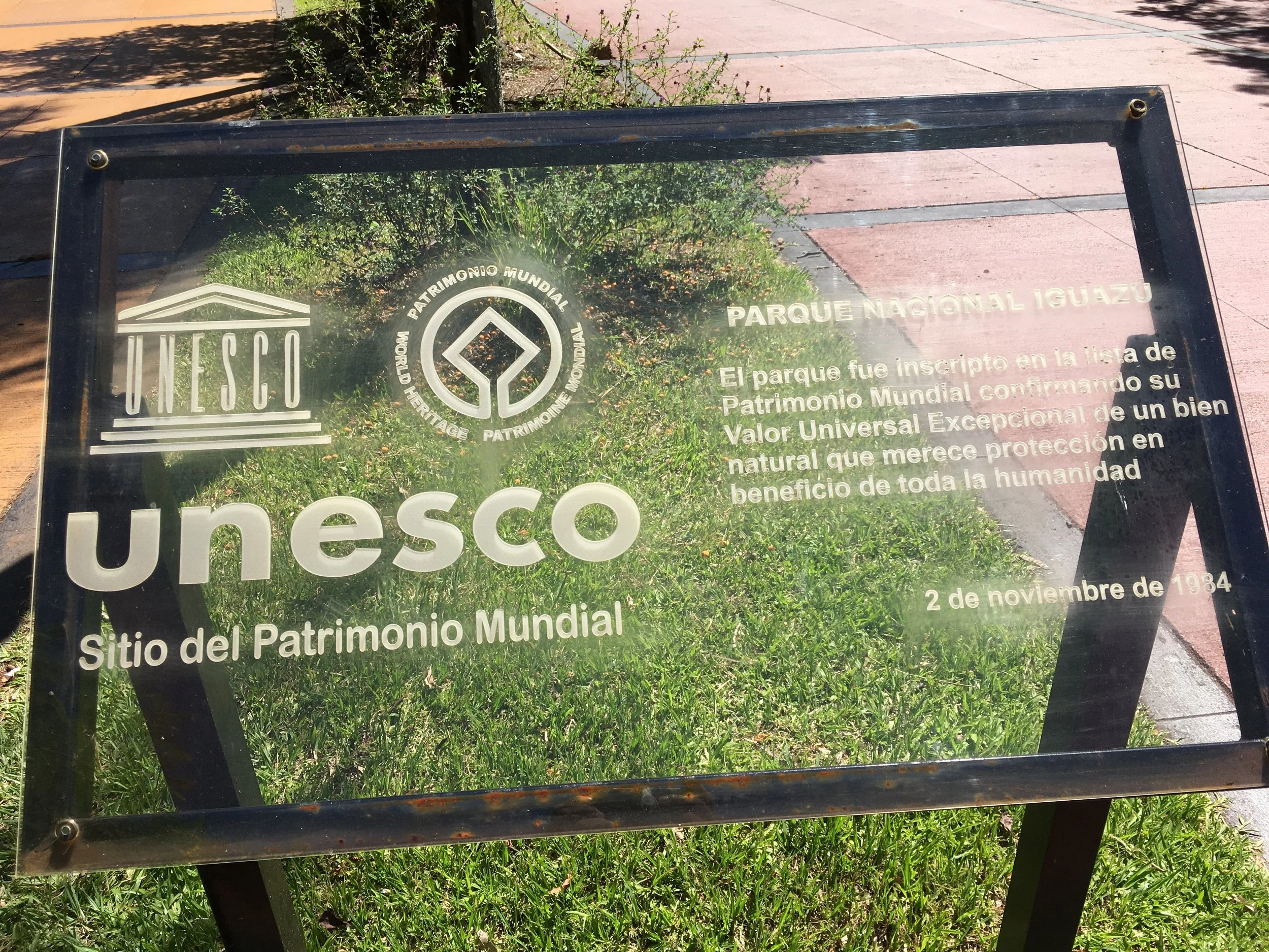 Informational sign about Iguazu National Park, a UNESCO World Heritage Site, inscribed on November 2, 1984, with the UNESCO logos and Spanish text explaining its significance.