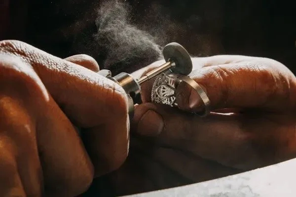 Close-up of an elderly person's hands holding a tattoo machine while creating a tattoo.