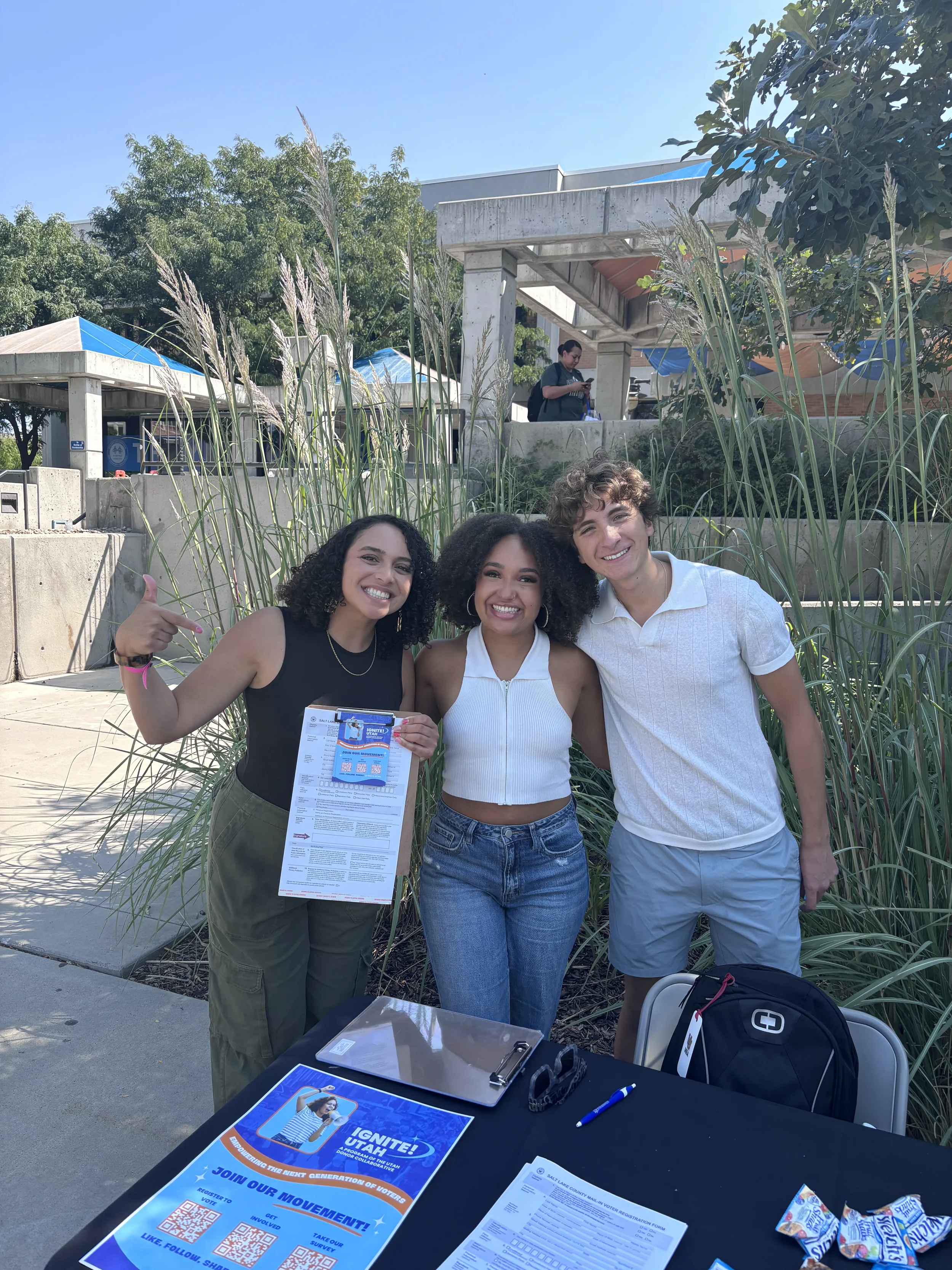 three Gen-Z students at a table promoting Ignite! Utah on campus.