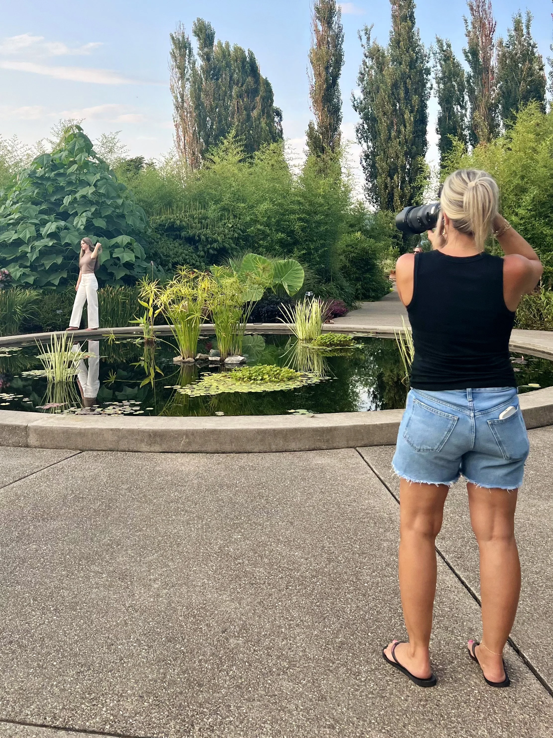 Tish OConnor Photography Senior Portrait session behind the scenes of Tish OConnor taking pic across pond of high school senior walking by water 