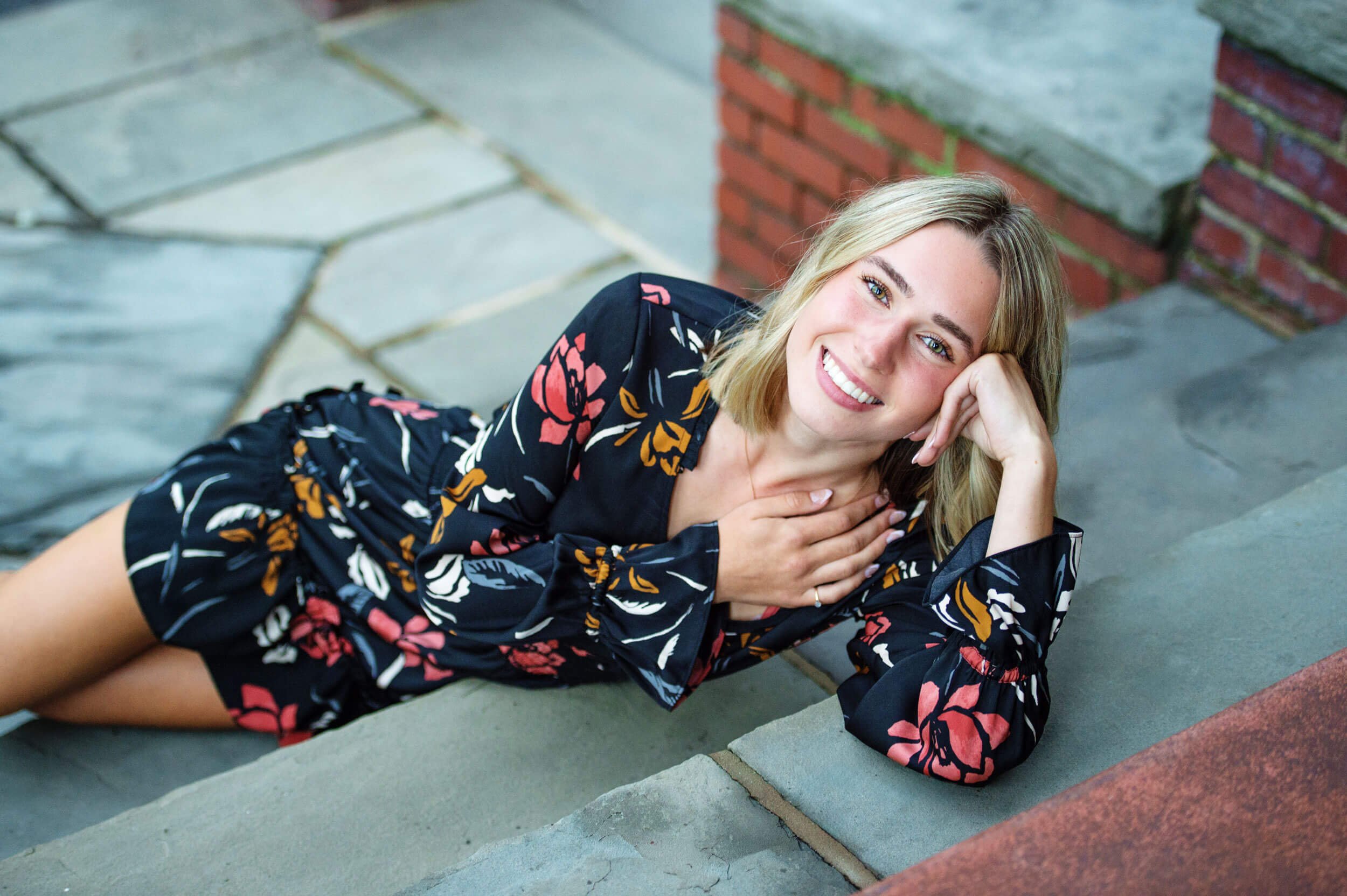 High School senior girl laying on stops resting hand on head at the Bush House in Muncy PA 