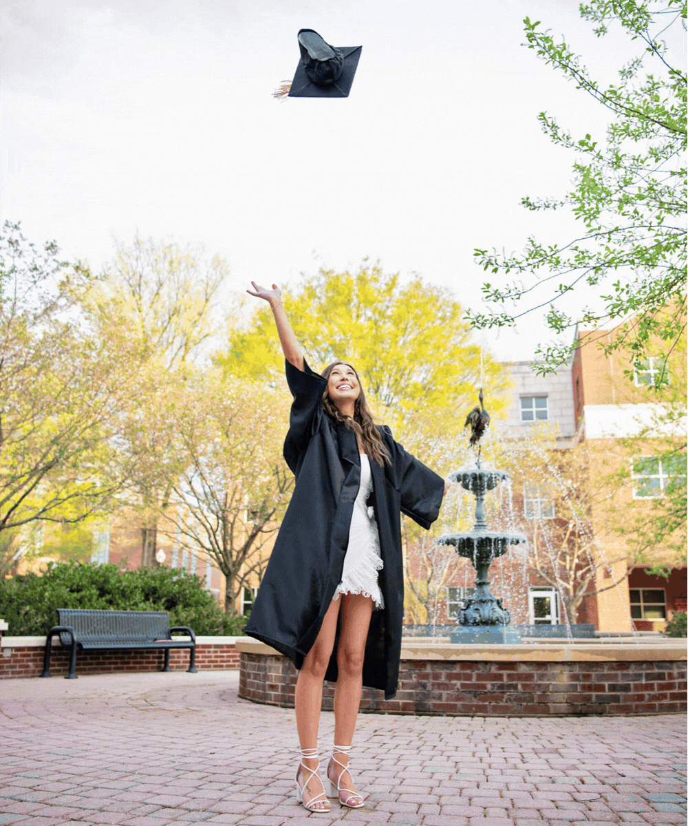 gif of two best friends for senior photos - one in white dress and one in black dress - holding hands walking and looking at eachother 