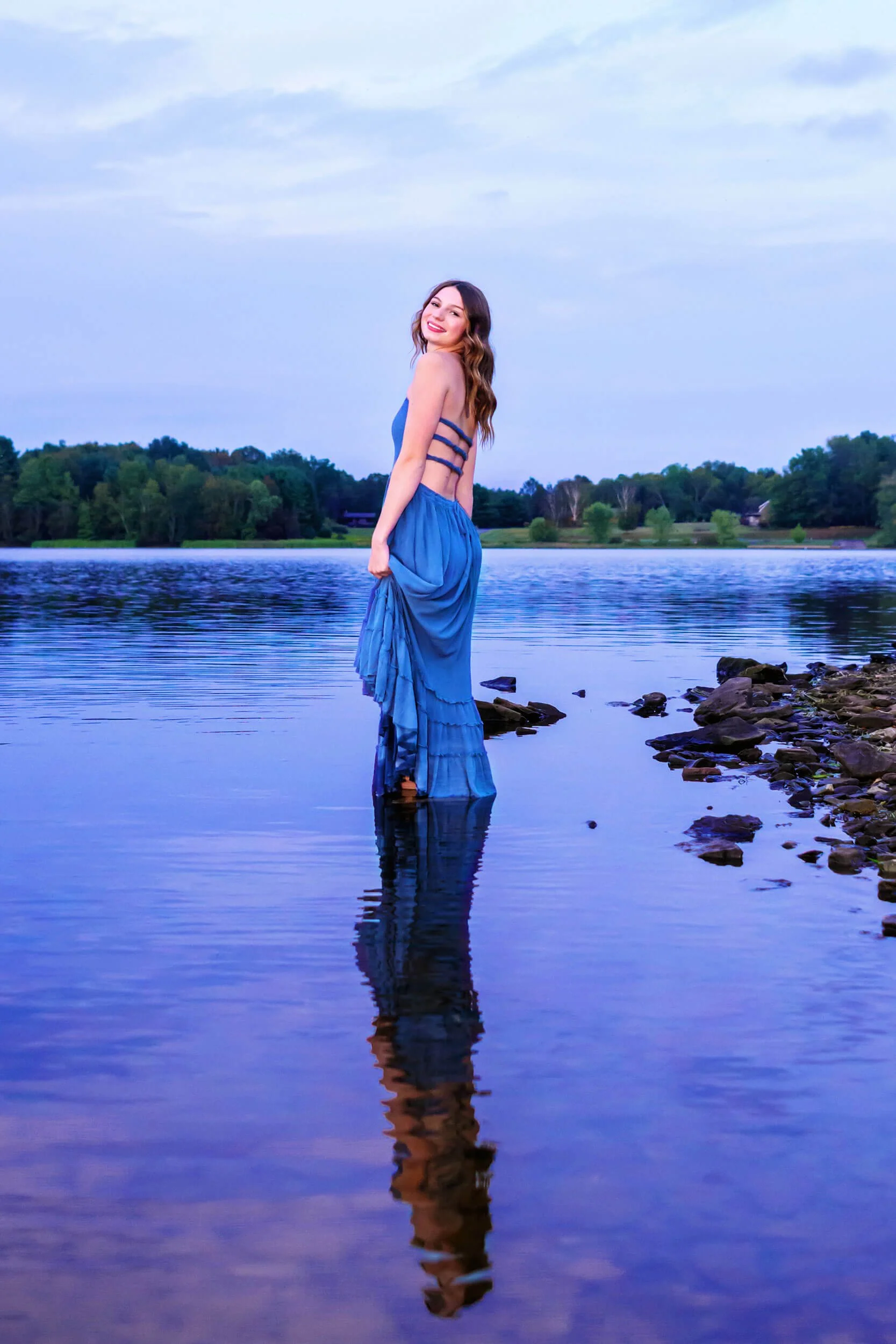 Williamsport PA  senior girl in a long blue flowy dress holding it up out of the water at Rose Valley lake - Tish OConnor Photography senior portraits