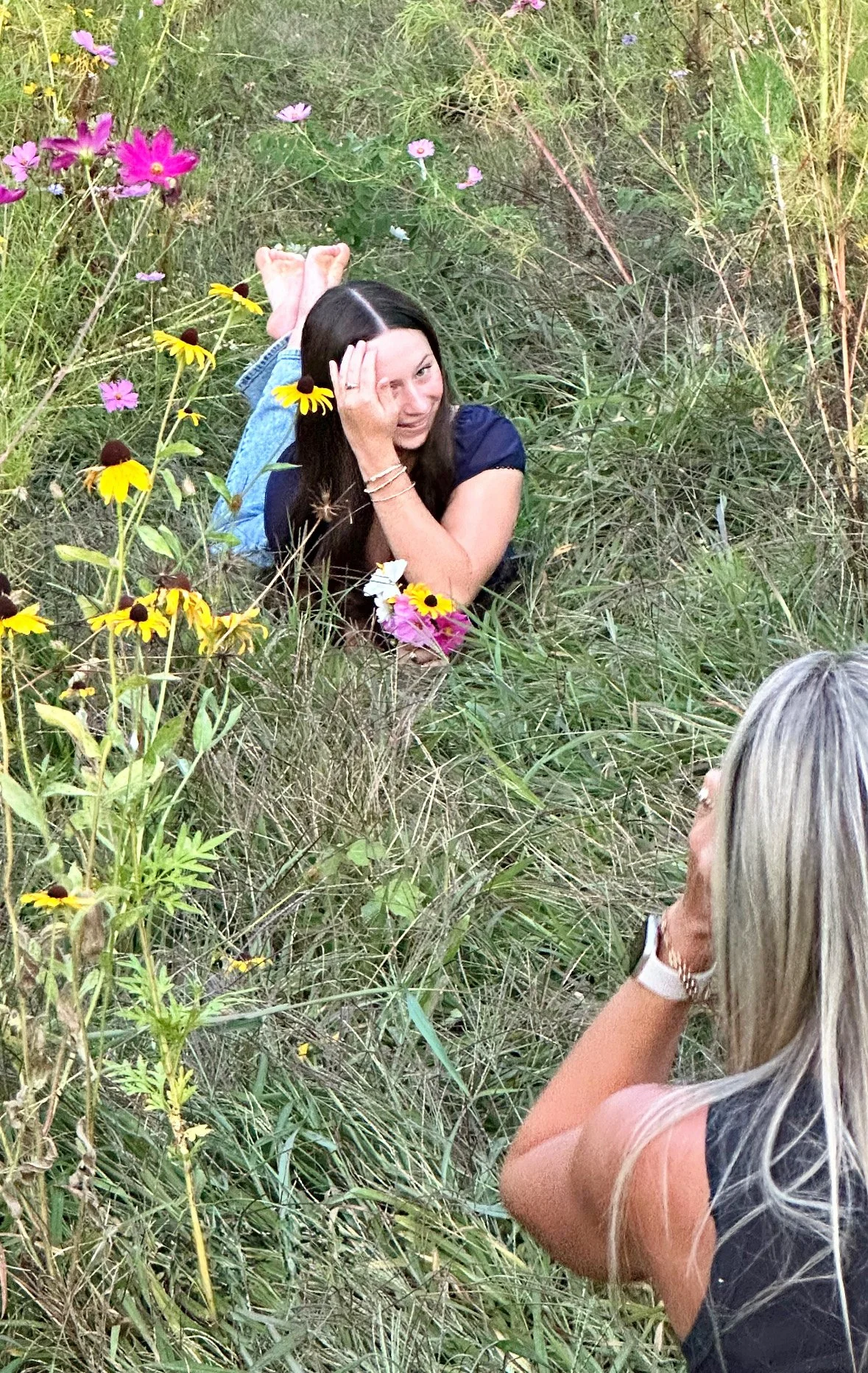 Behind the scenes pic of Tish OConnor Photography senior portrait of senior girl laying on stomach in flower field Williamsport PA 