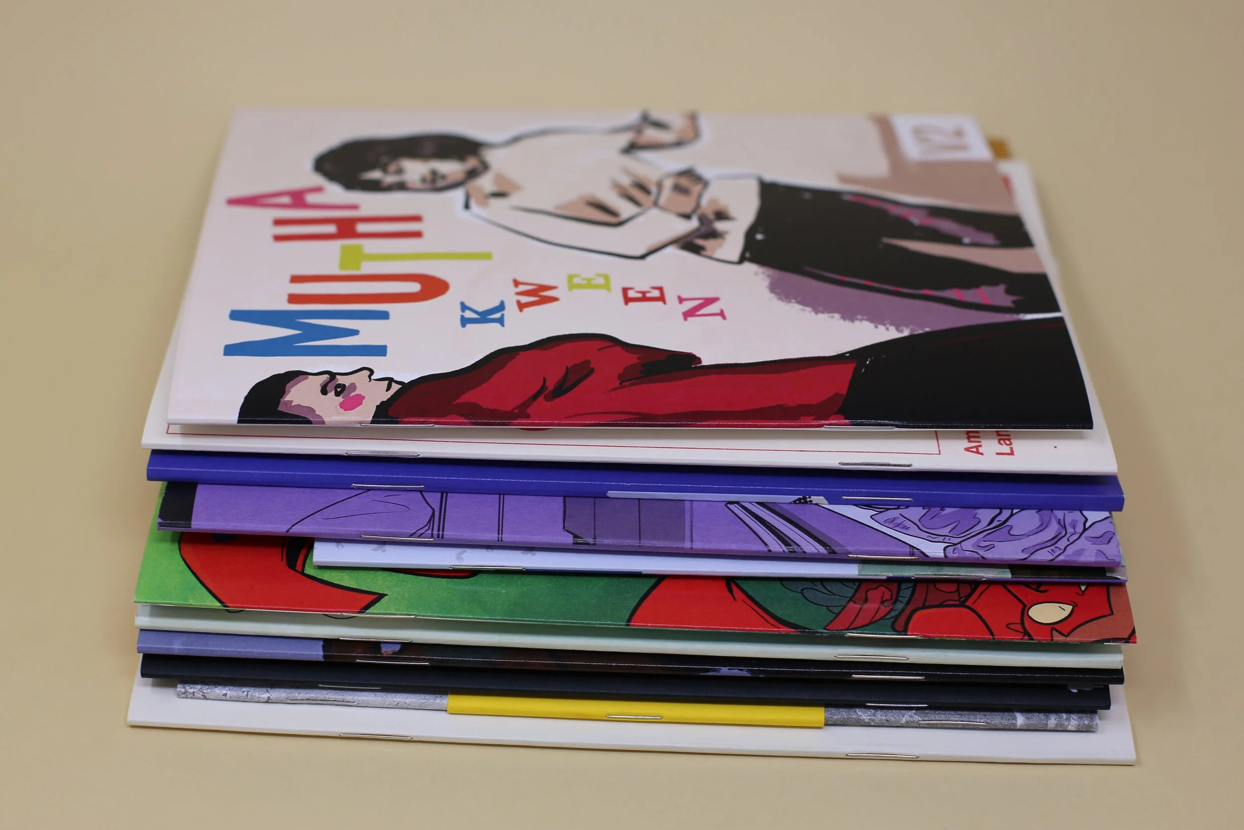 Stack of zines, showing the staple side off