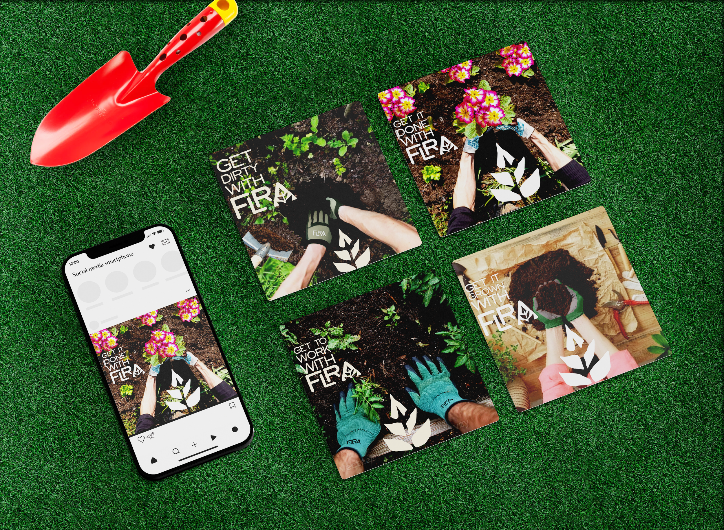 Flat lay of gardening themed posters, a smartphone, and gardening tools on artificial grass. The posters feature images of hands planting and tending to plants with phrases like 'Get Dirty with FRA,' 'Get It Done with FRA,' and 'Get It Grow with FRA.