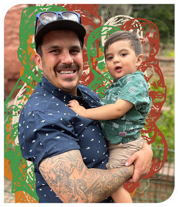 Smiling man with tattooed arm holding a young child outdoors, with abstract orange, green, and cream line-art shapes layered behind them in a rounded-frame portrait.