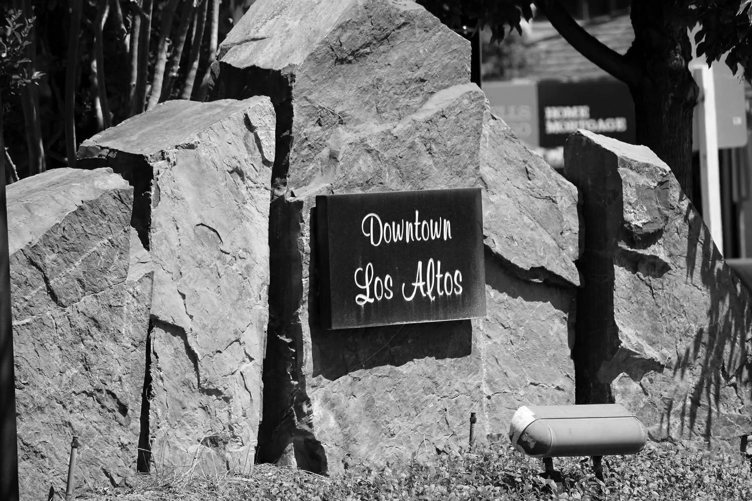 A large rock formation with a sign that reads 'Downtown Los Altos' in front of it.