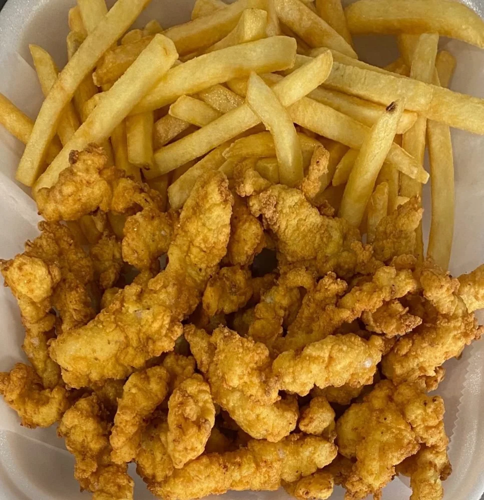 Fried chicken strips and French fries in a takeout container.