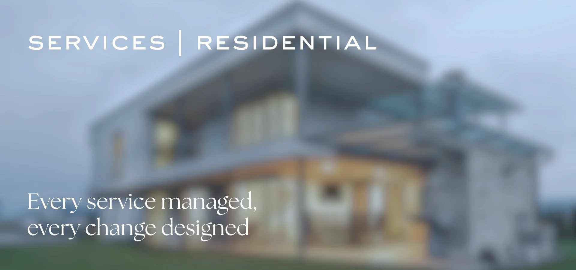 A modern house with large windows and a sloped roof, blurred background, advertising residential services.