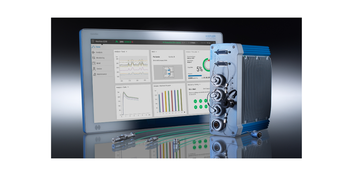 A high-tech industrial device with cables connected, a digital display monitor showing data, and electronic components on a reflective surface.