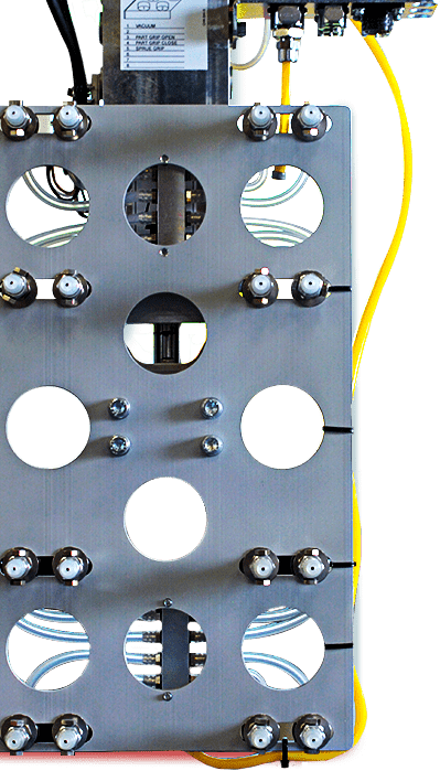 Close-up of a metal electrical or mechanical panel with circular cutouts, bolts, and yellow wiring.