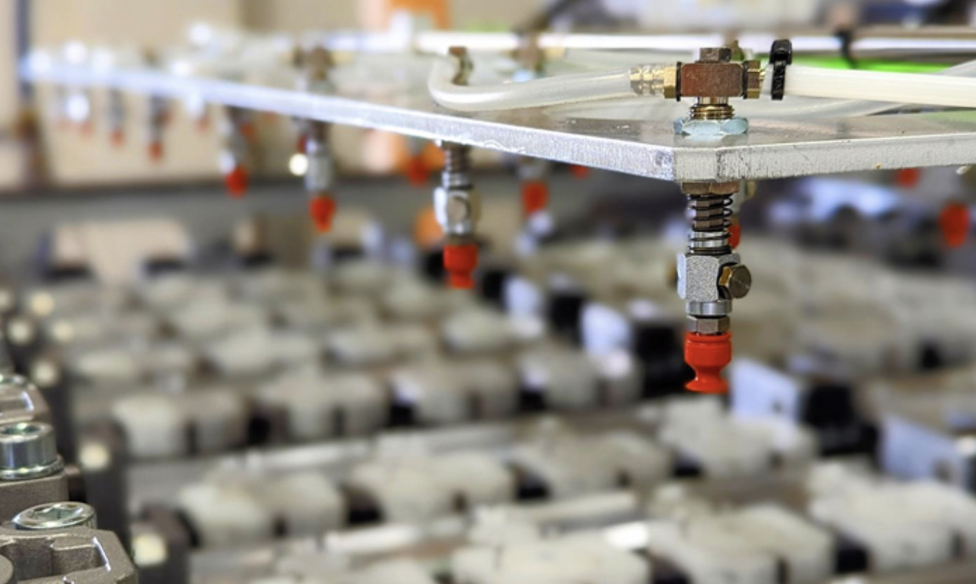 Close-up of plumbing pipes and fittings with a blurred background of metallic components and mechanical parts.