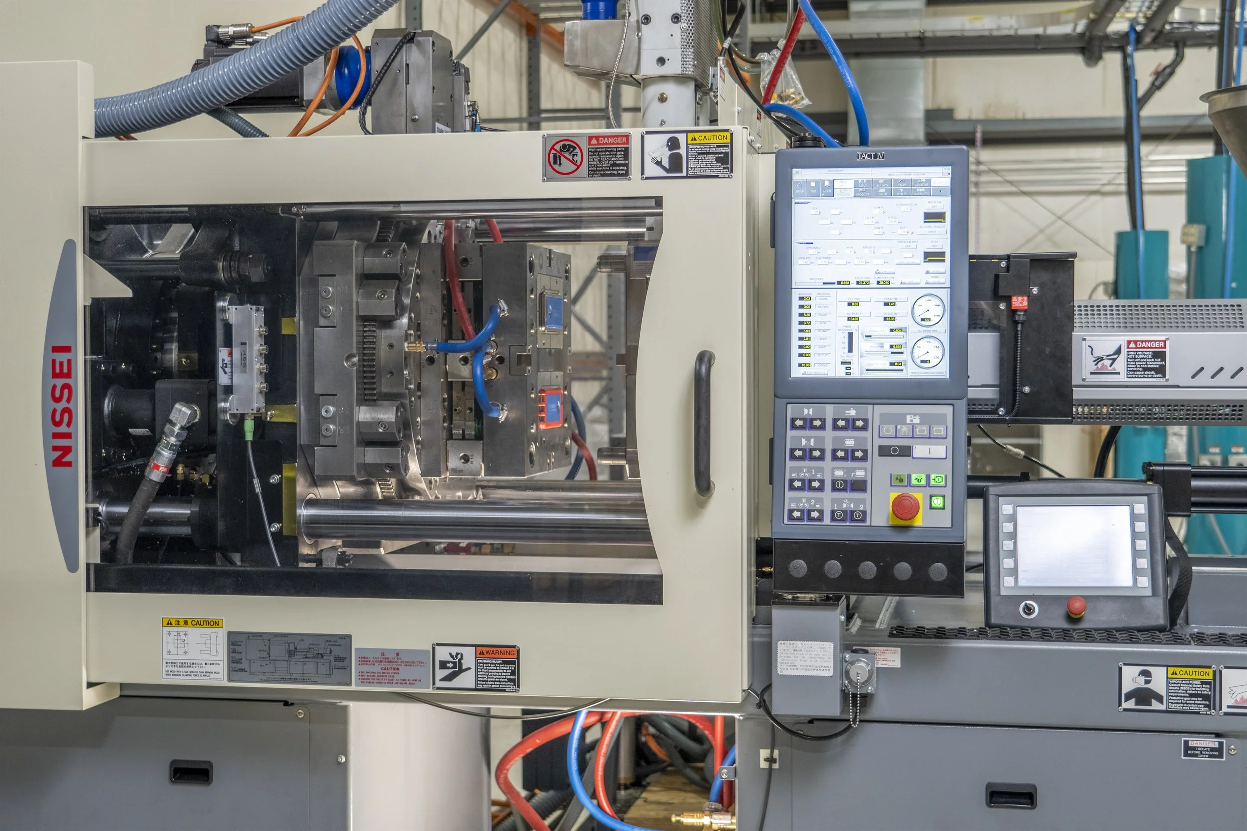 A CNC machine with digital control panels in an industrial setting.