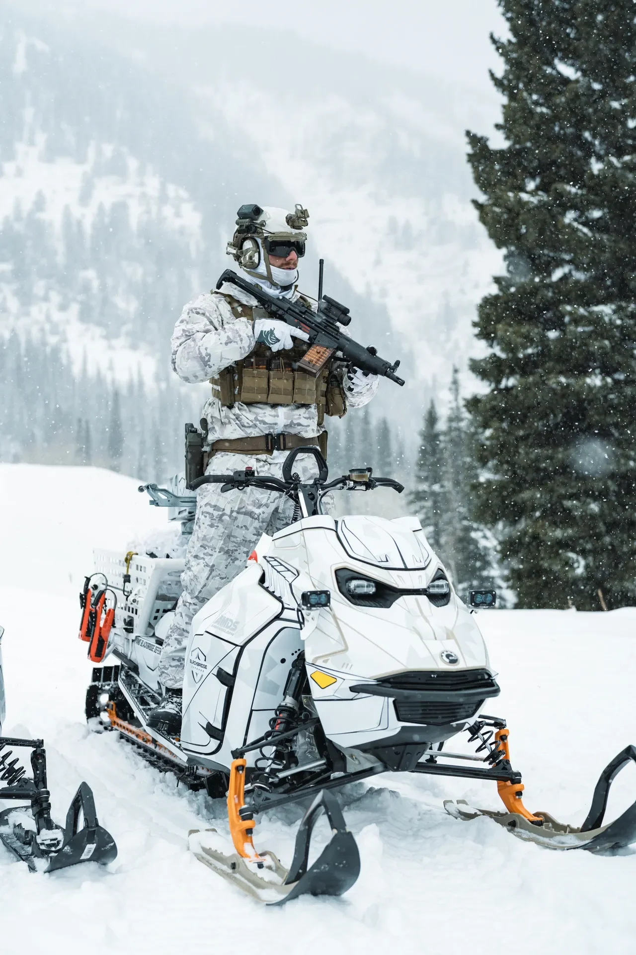 A close-up of a man on a snowmobile developed for winterwarfare.