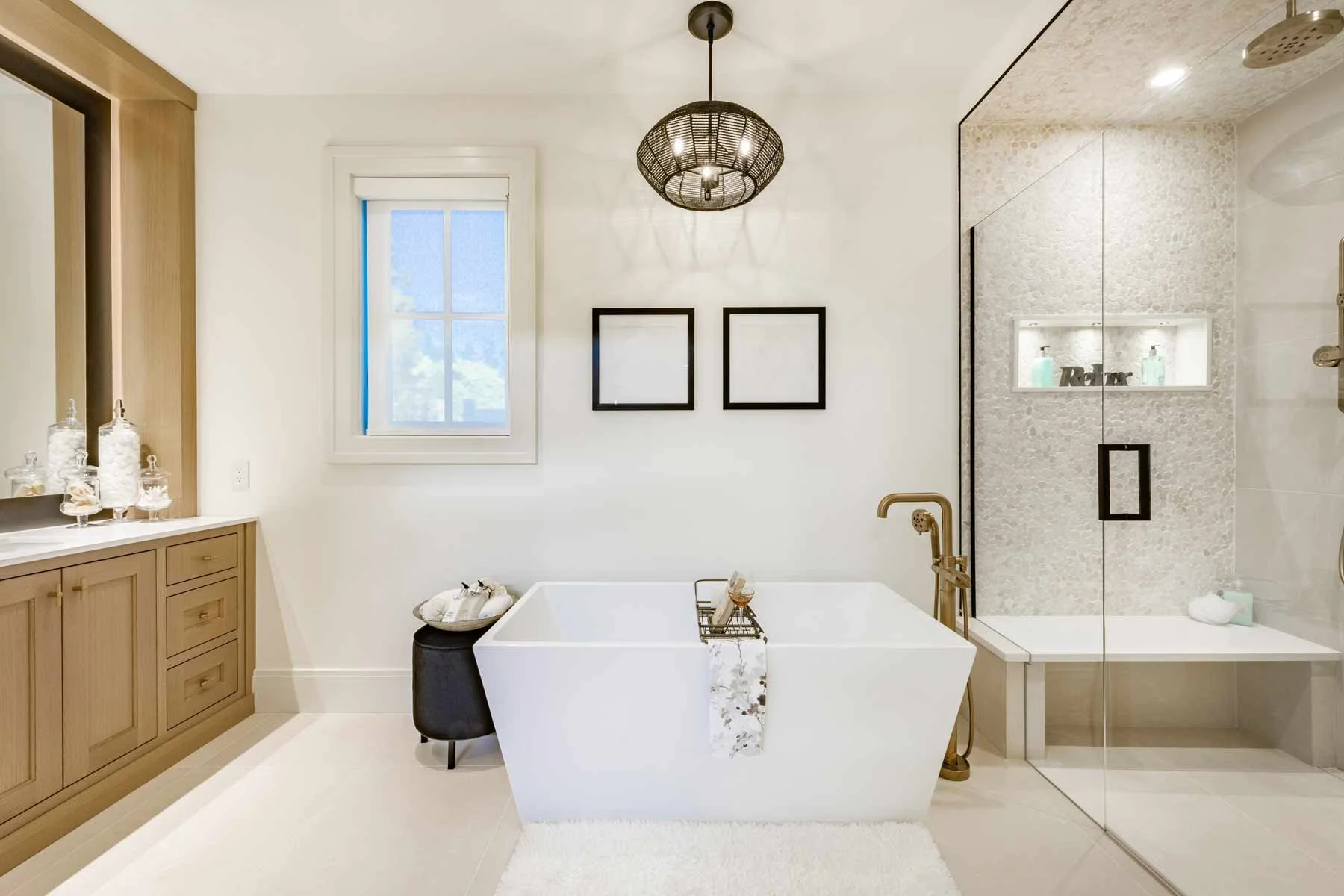 Bathroom with a freestanding bathtub, a shower area with built-in shelves, wooden cabinetry, and a window, decorated in neutral tones.